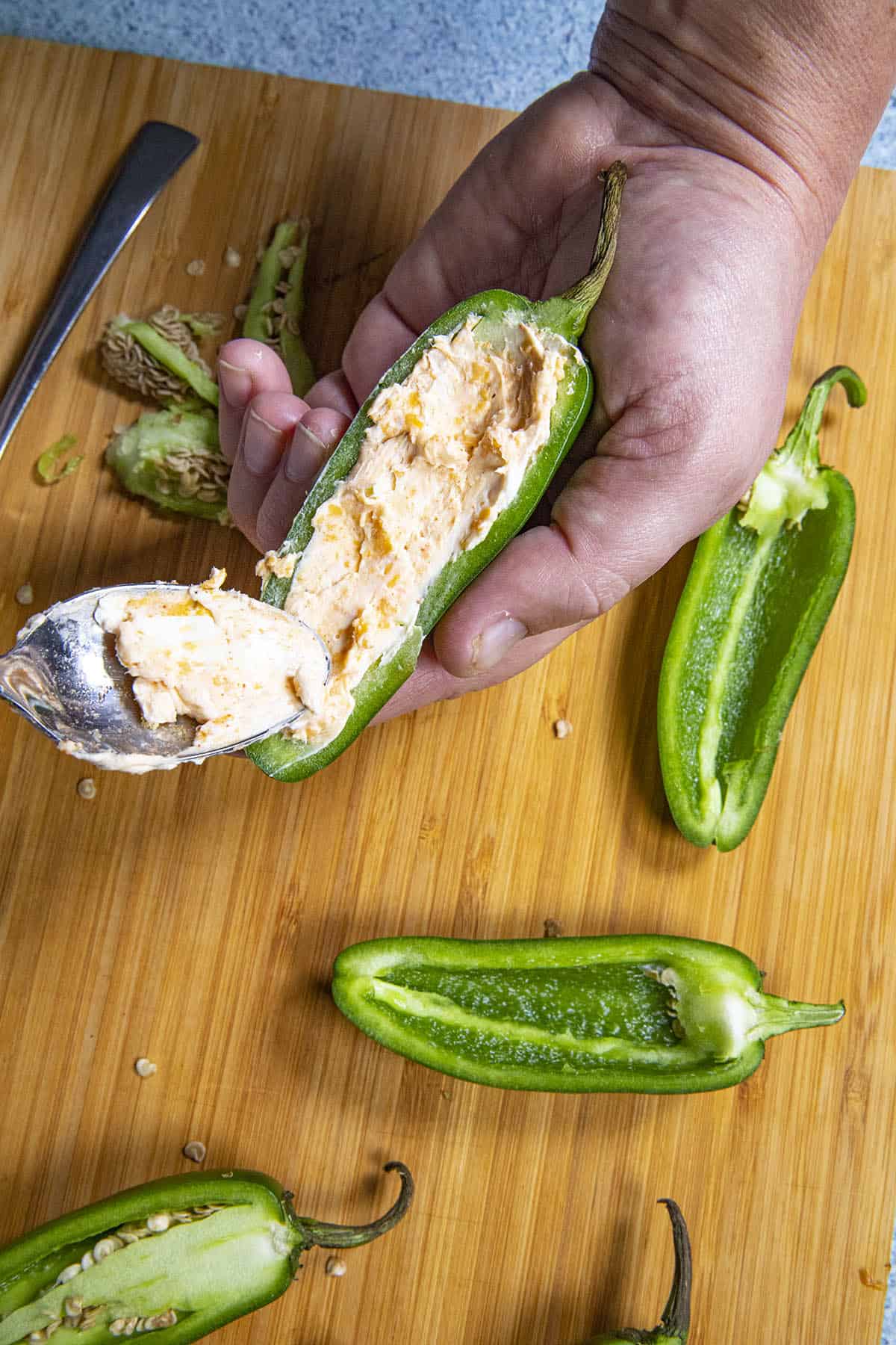Stuffing jalapeno poppers with cheese