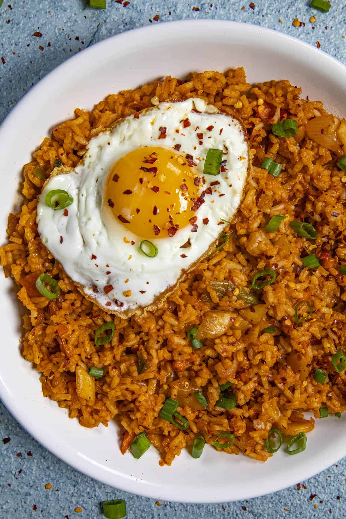 A beautiful fried egg on top of a bowl of spicy kimchi fried rice