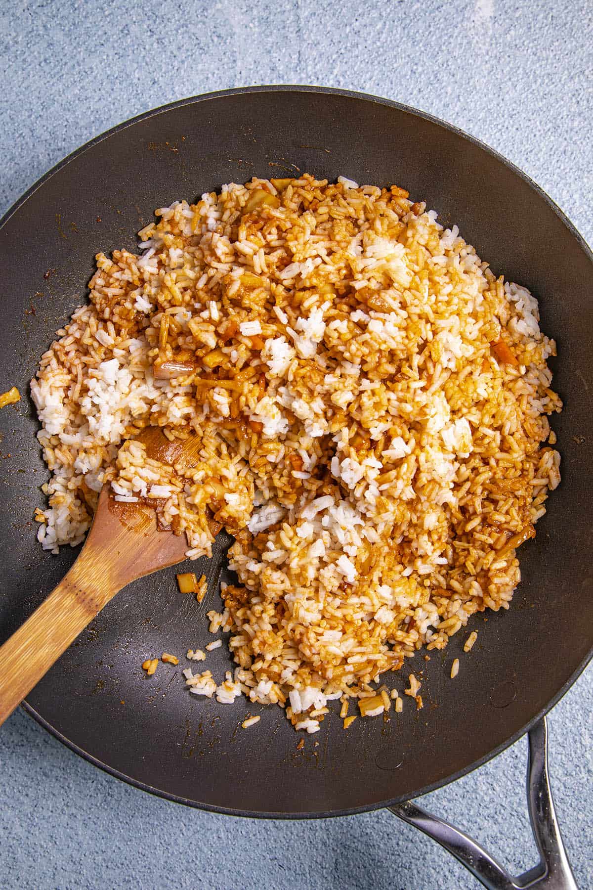 Stirring the sauce into the kimchi fried rice in a hot pan