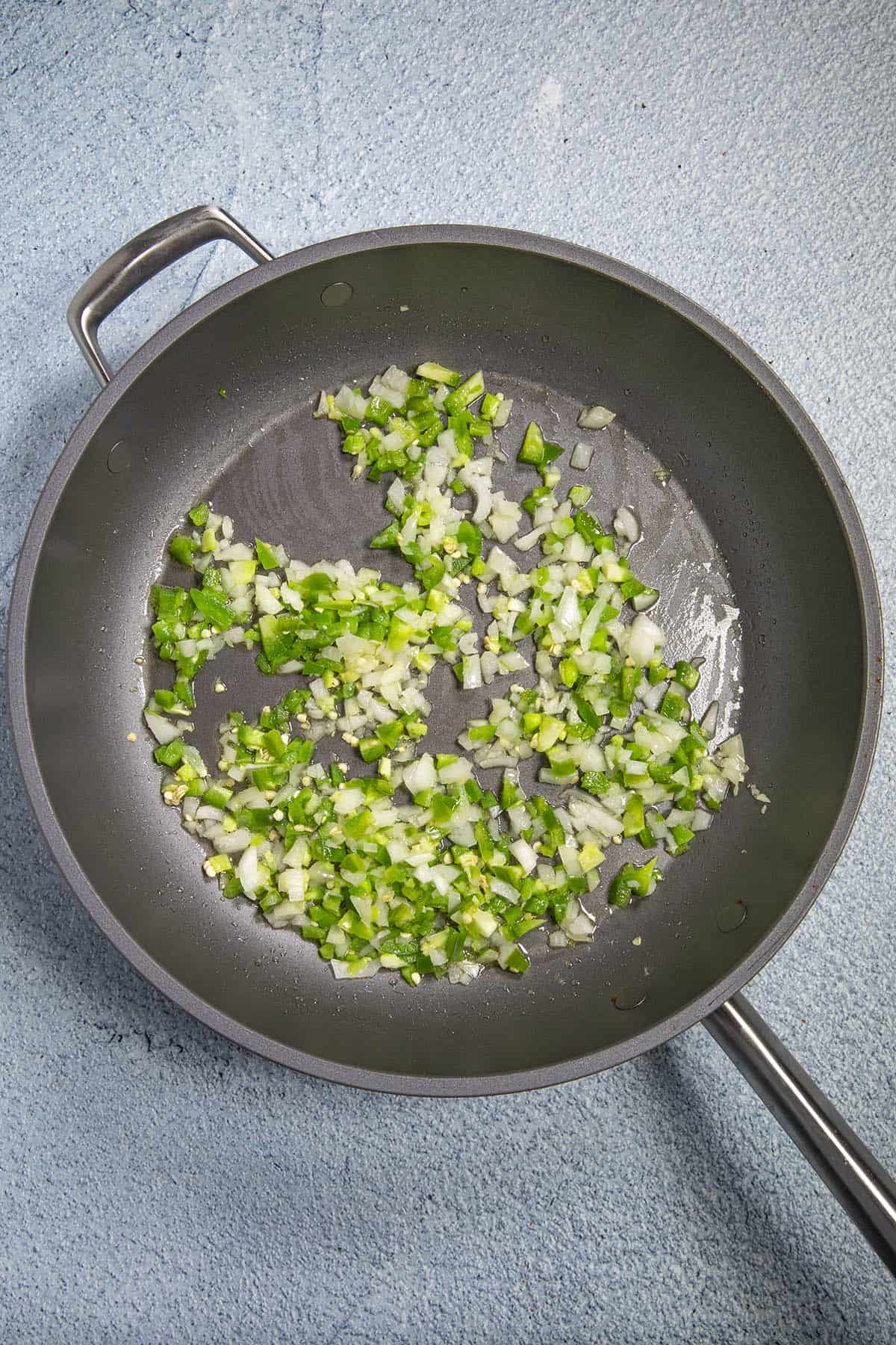 Cooking peppers and onions in a hot pan