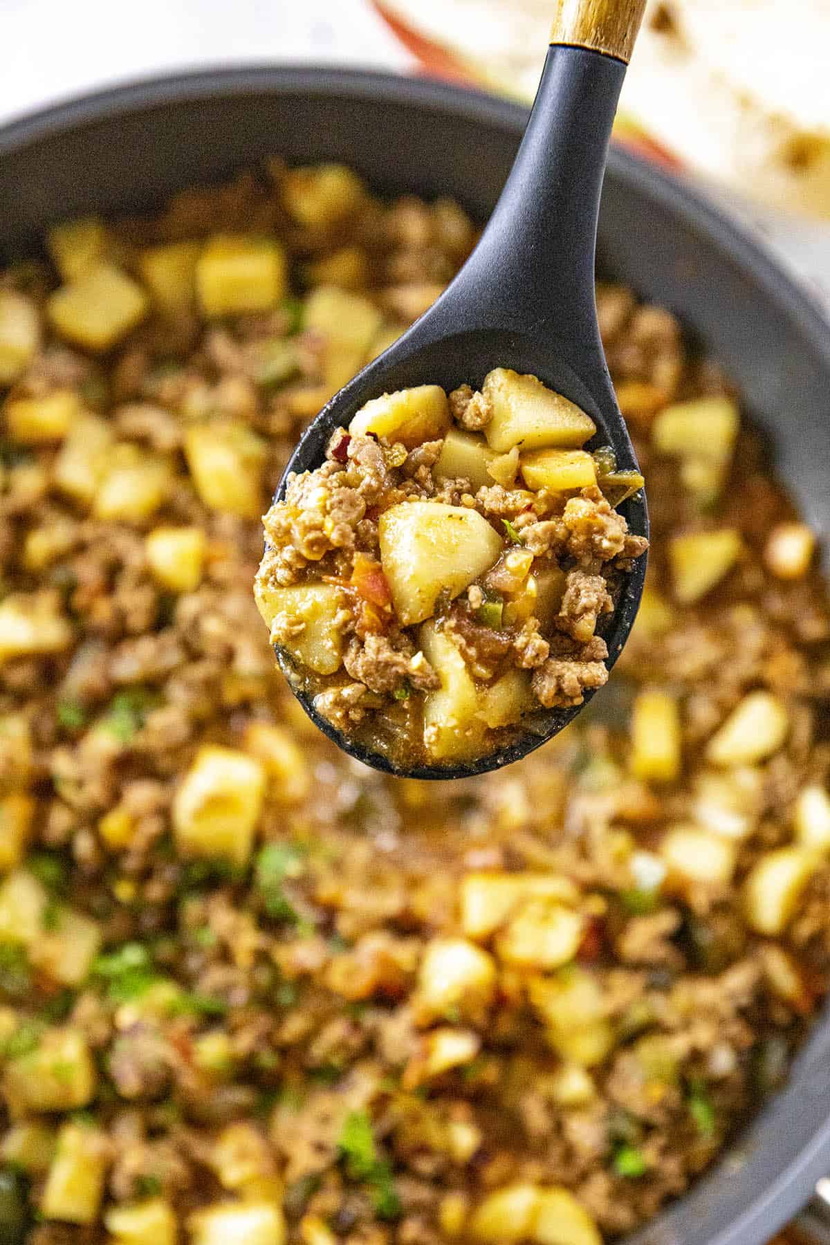 A large scoop of Mexican Picadillo on a spoon