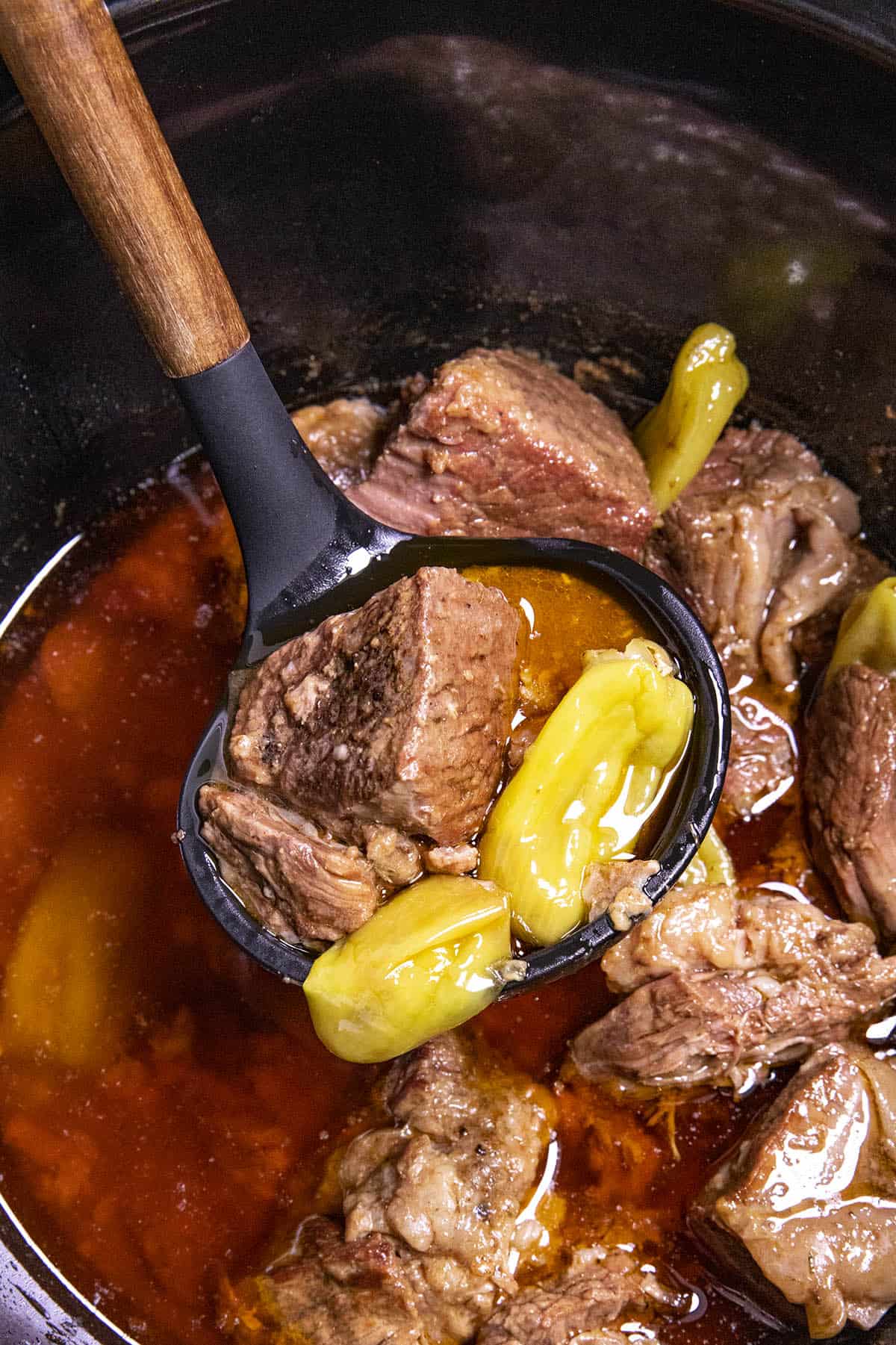 A ladle full of Mississippi Pot Roast with pepperoncinis