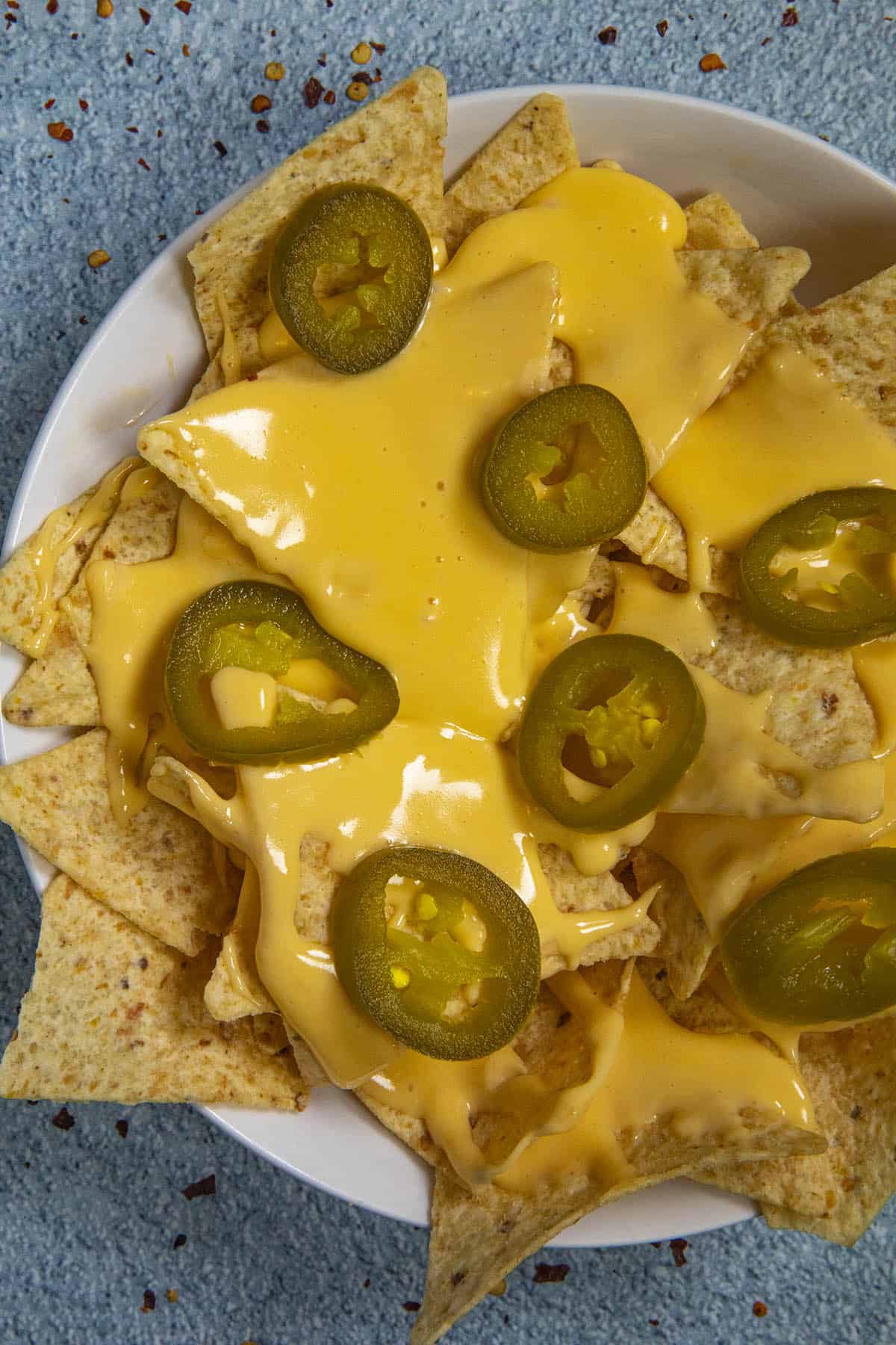 Cheesy nachos in a bowl with homemade nacho cheese sauce