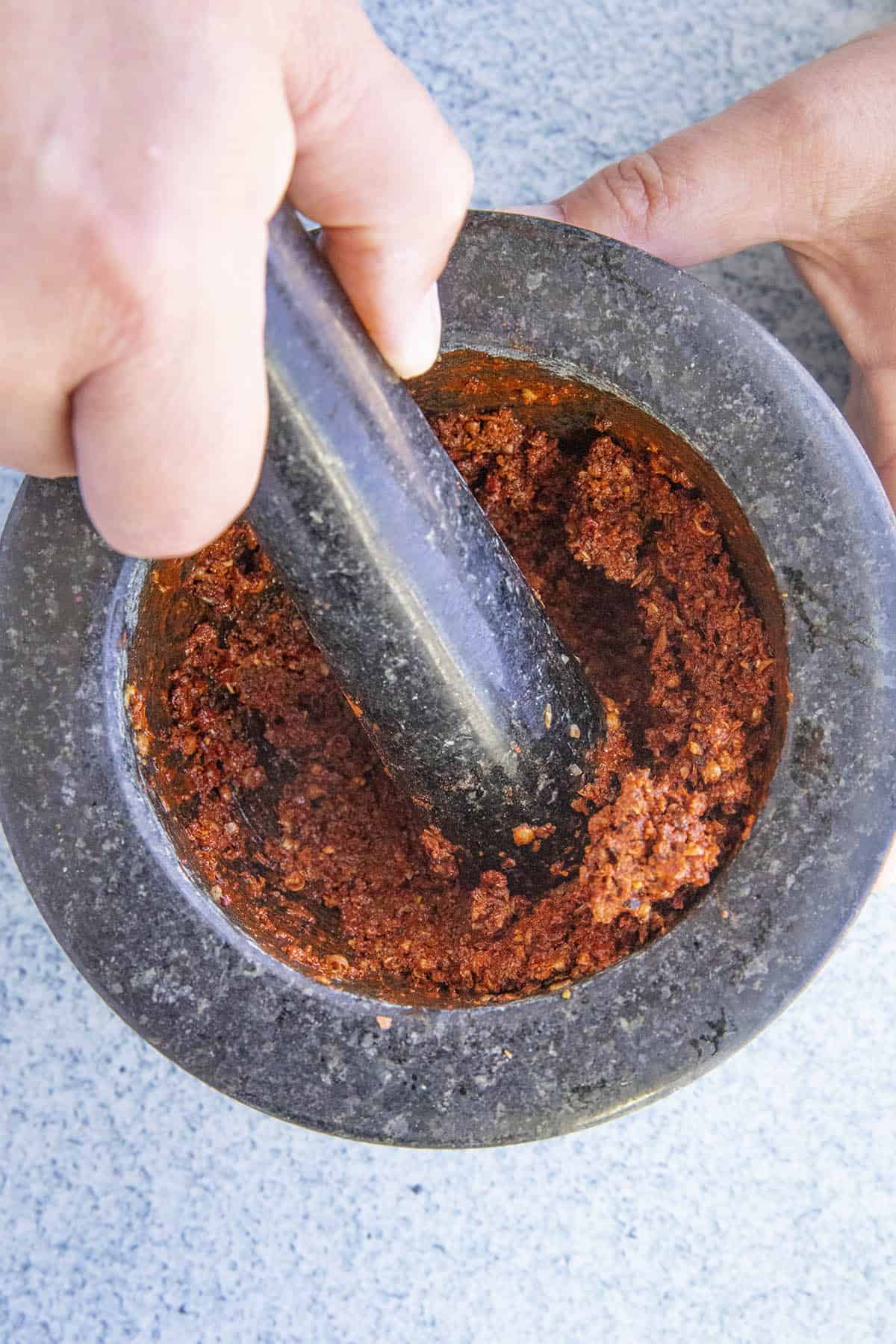 Mike grinding Achiote Paste in a mortar