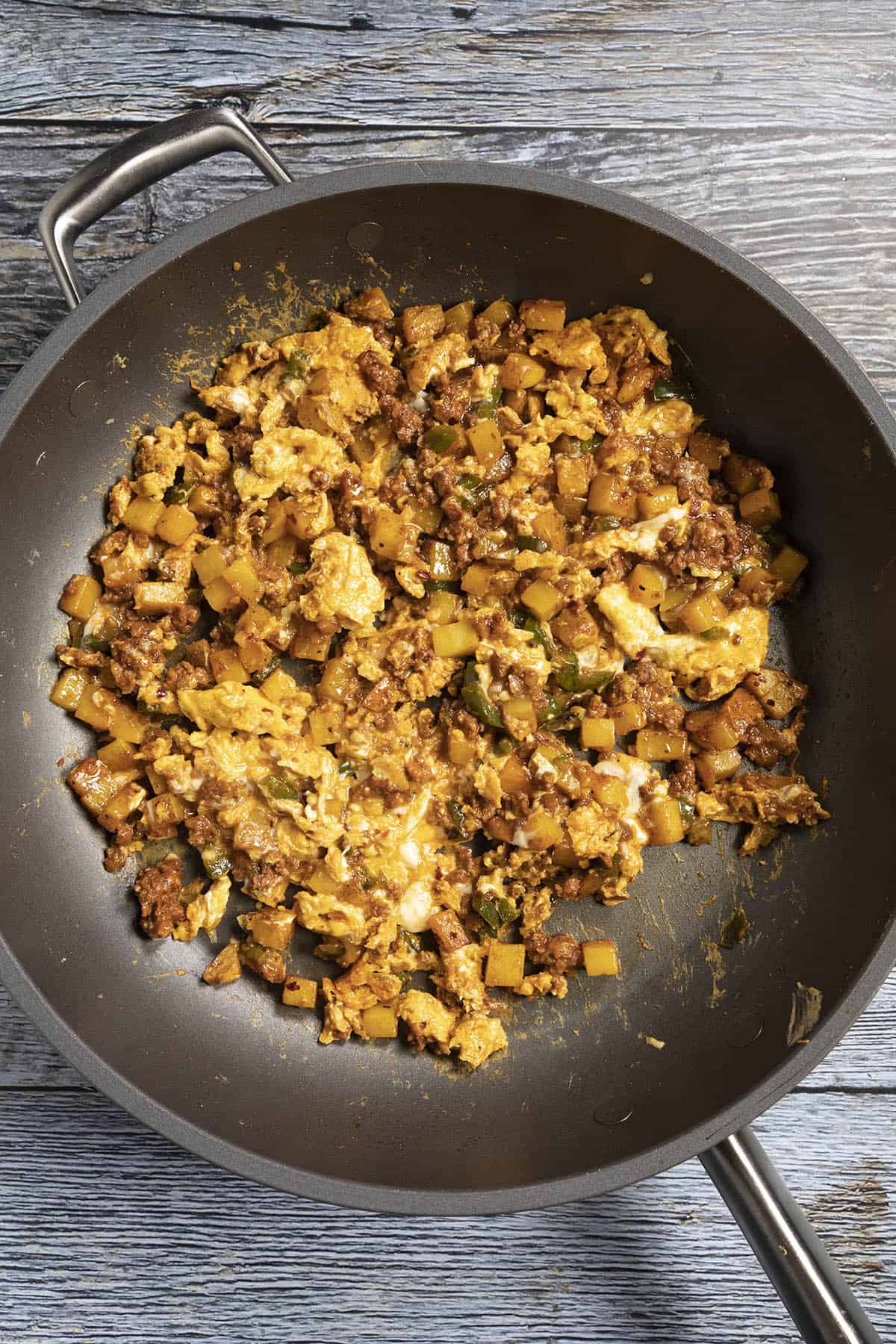 Scrambling the eggs into the pan with potatoes and chorizo