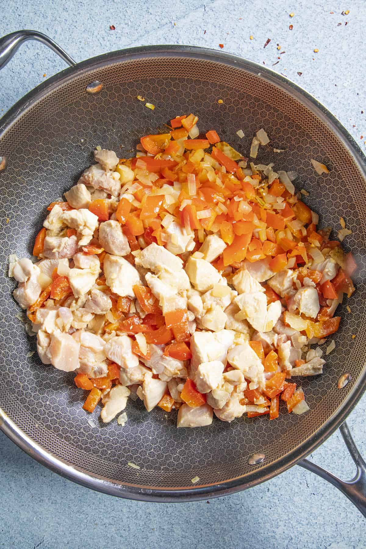 Cooking the chicken with the vegetables in the pan to make Panang Curry