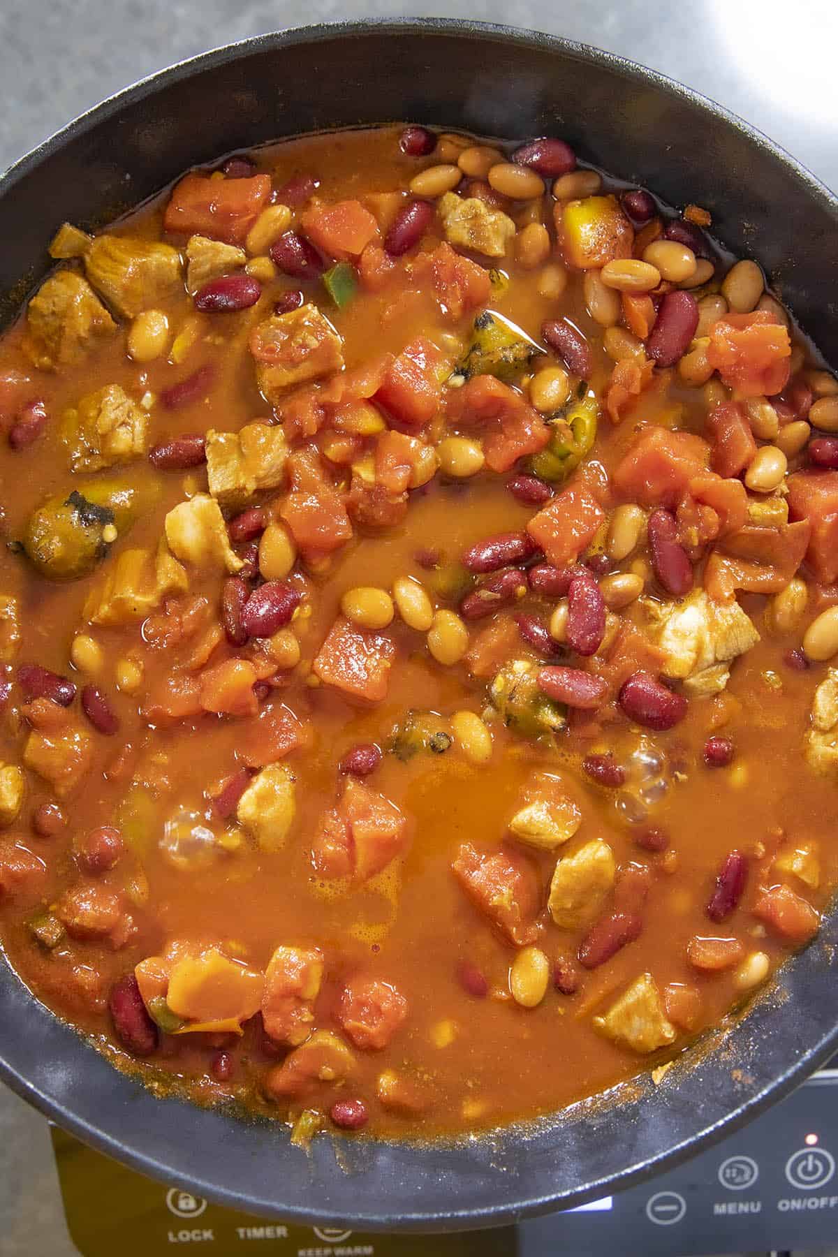 Adding beans to the Pork Chili with Roasted Hatch Chiles
