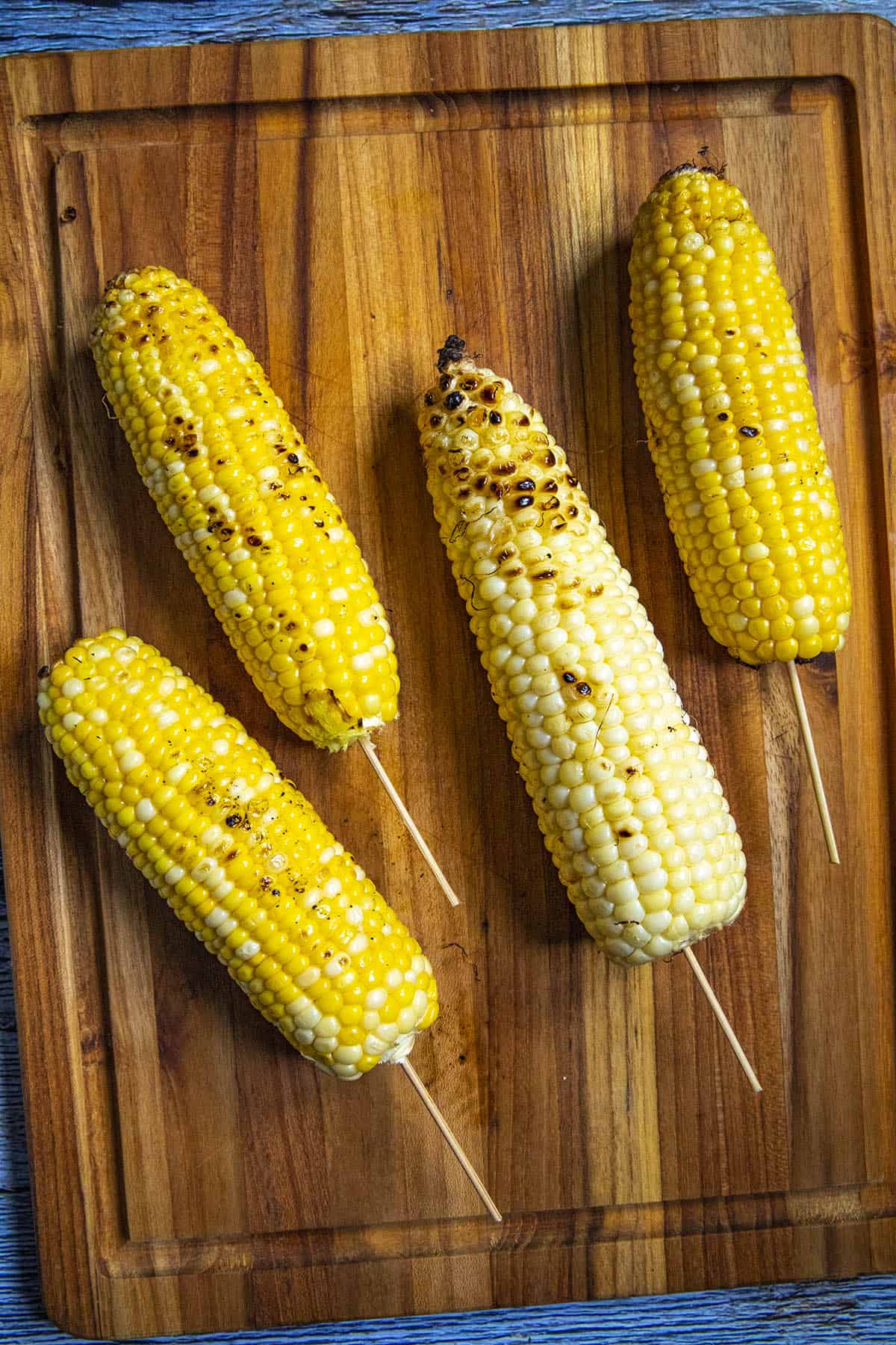 Adding skewers to the grilled corn