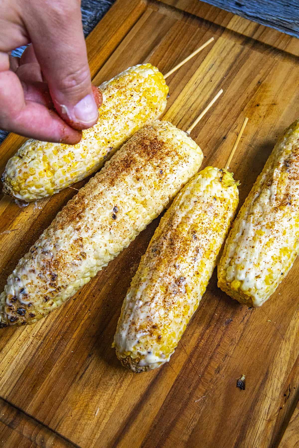 Coating the grilled corn with seasonings