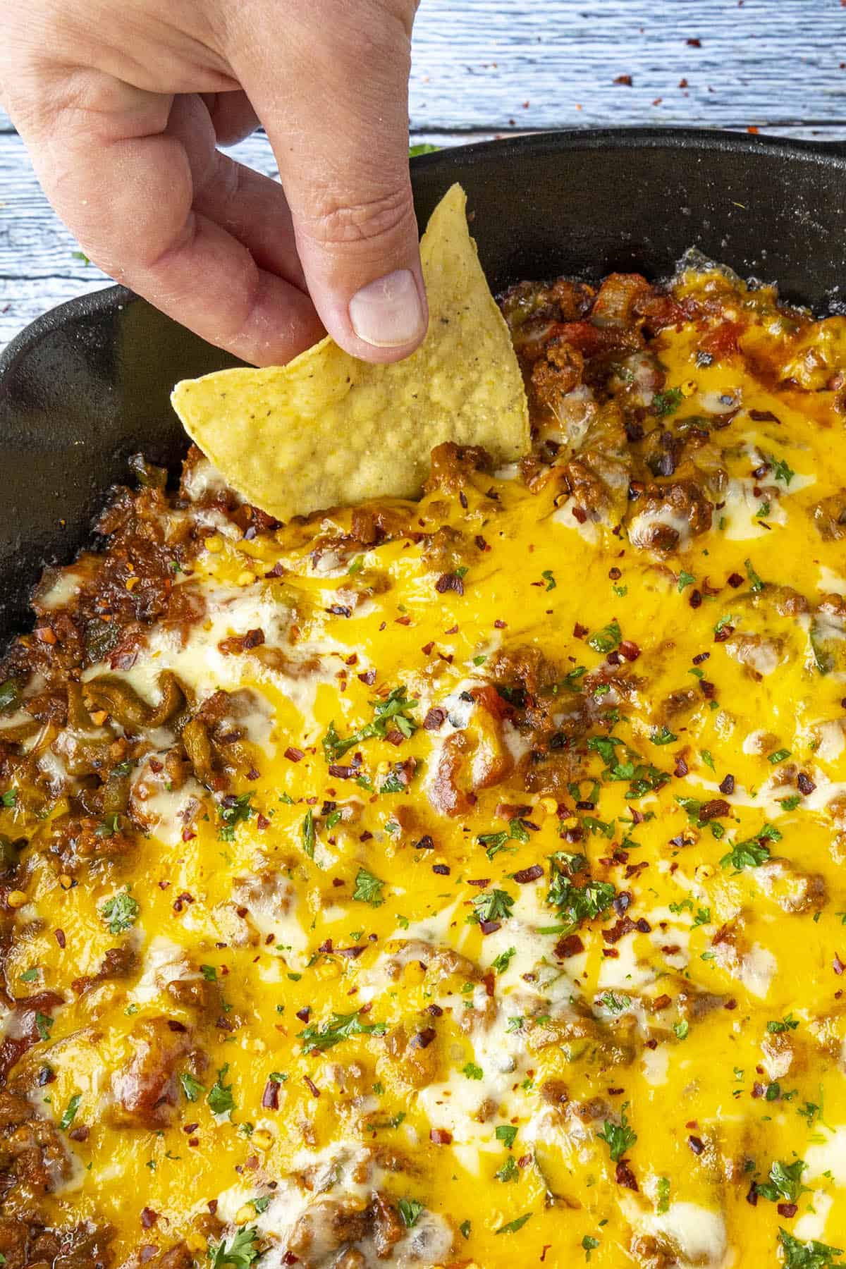 Mike taking a scoop of Chili Cheese Dip with a tortilla