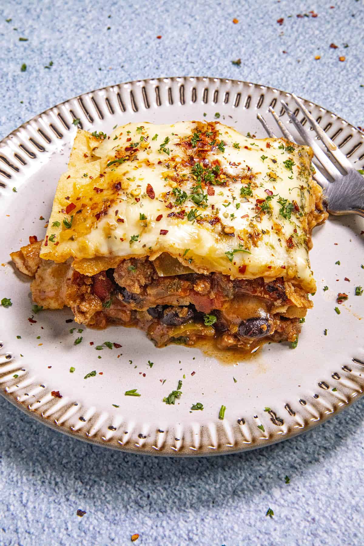 A slice of Cheesy Mexican Lasagna on a plate, ready to serve