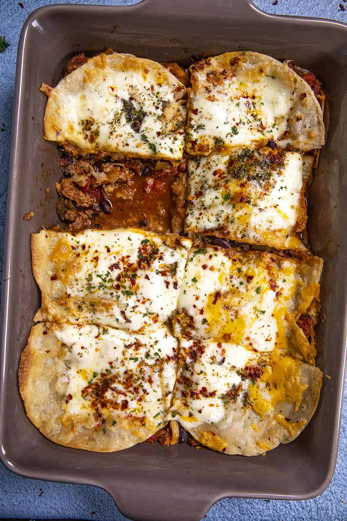 Cheesy Mexican Lasagna in a pan with one piece missing