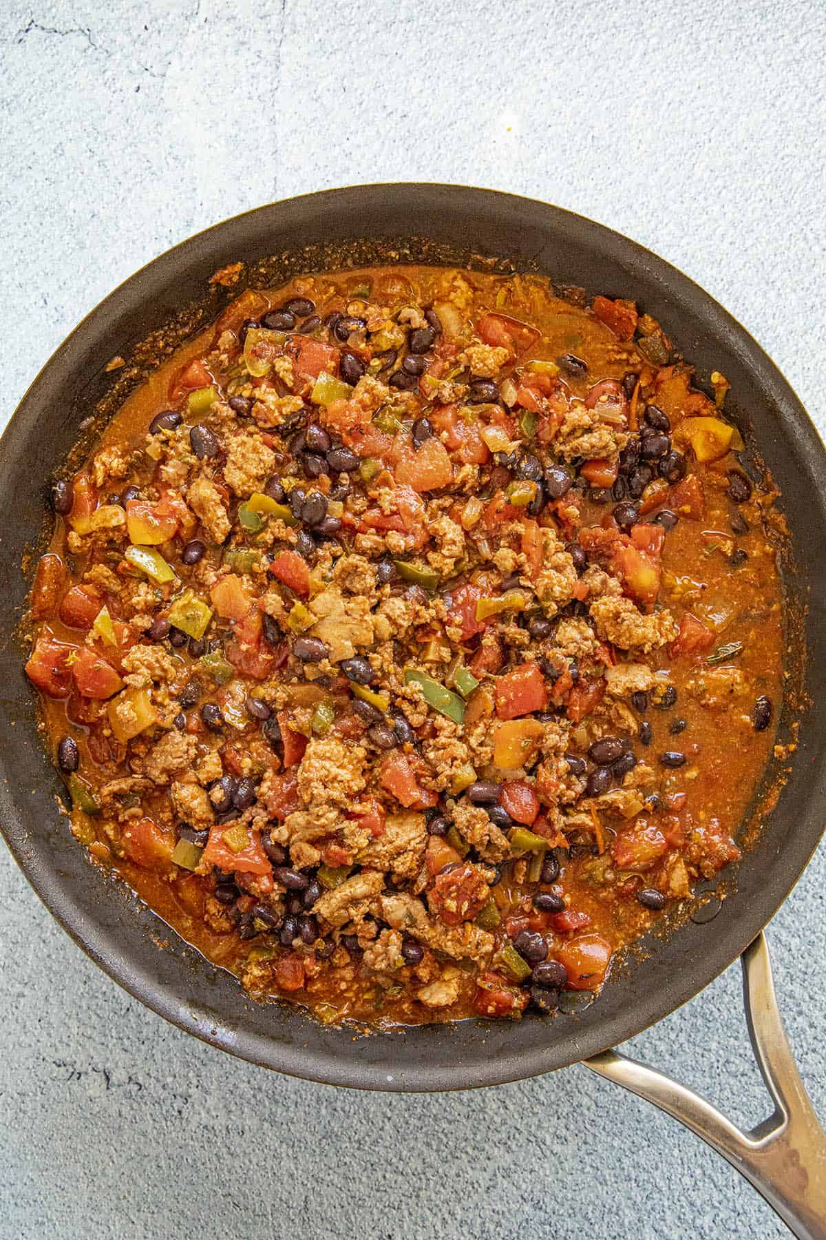 Cooked beef, beans, tomatoes and spices in a pan