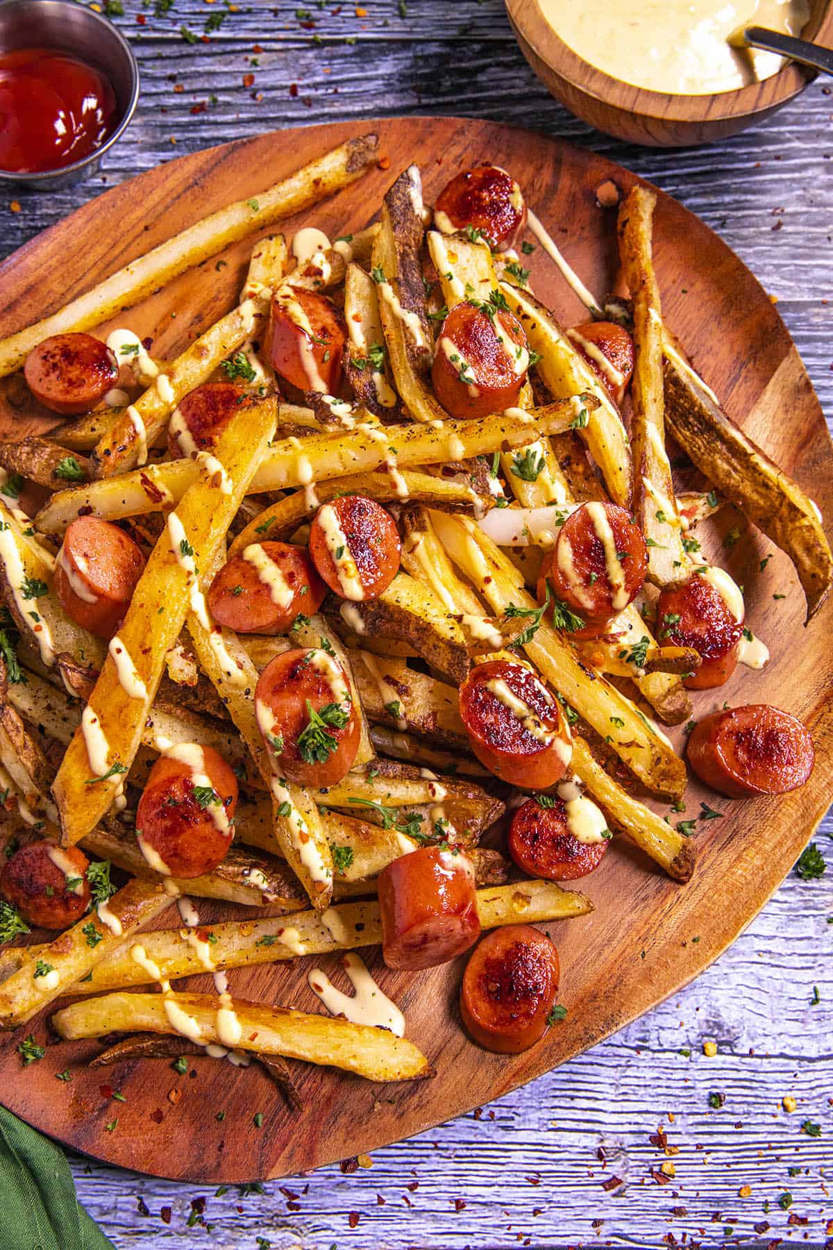 Salchipapas on a platter, ready to serve, with sauces on the side
