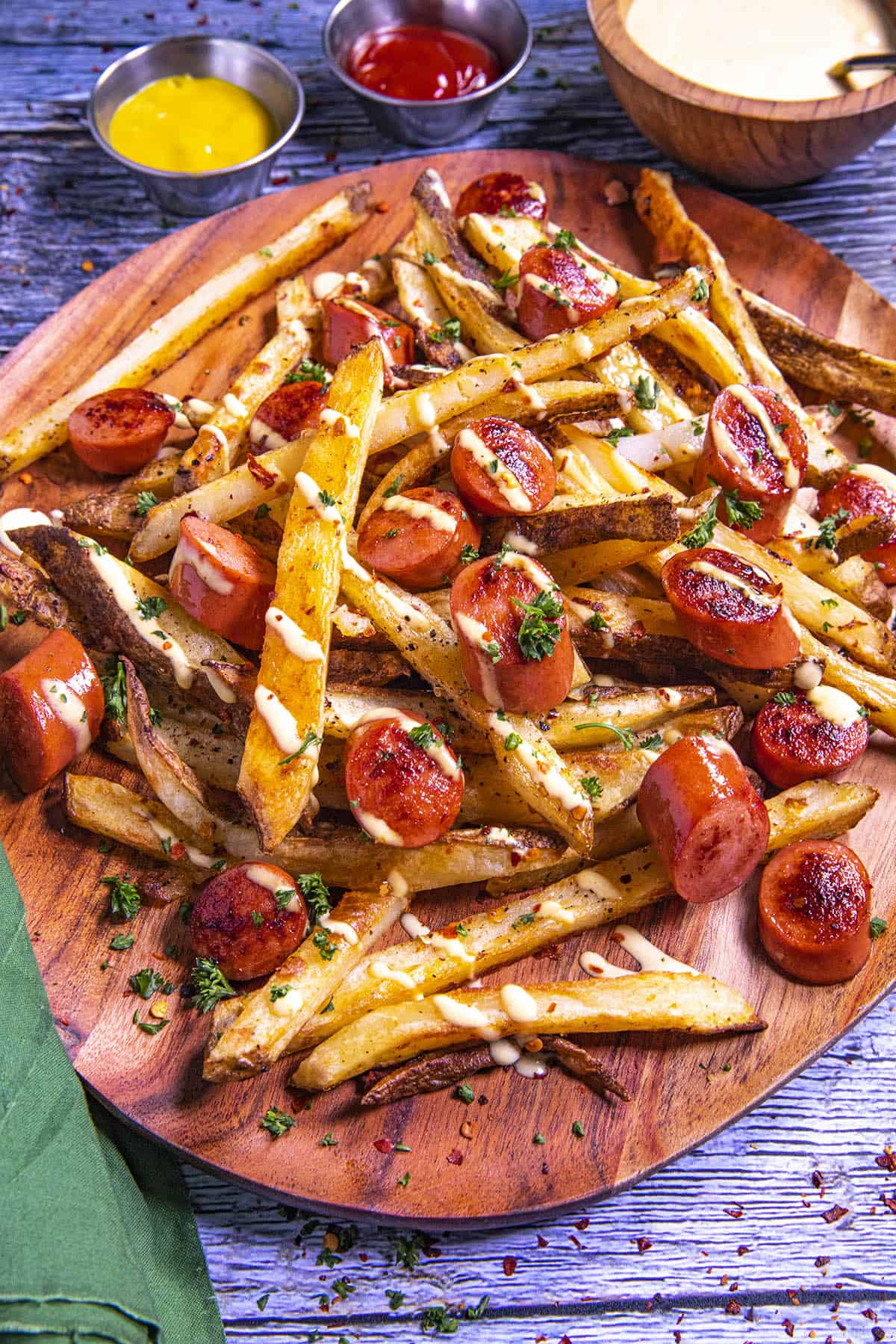 Salchipapas on a platter with lots of aji amarillo sauce