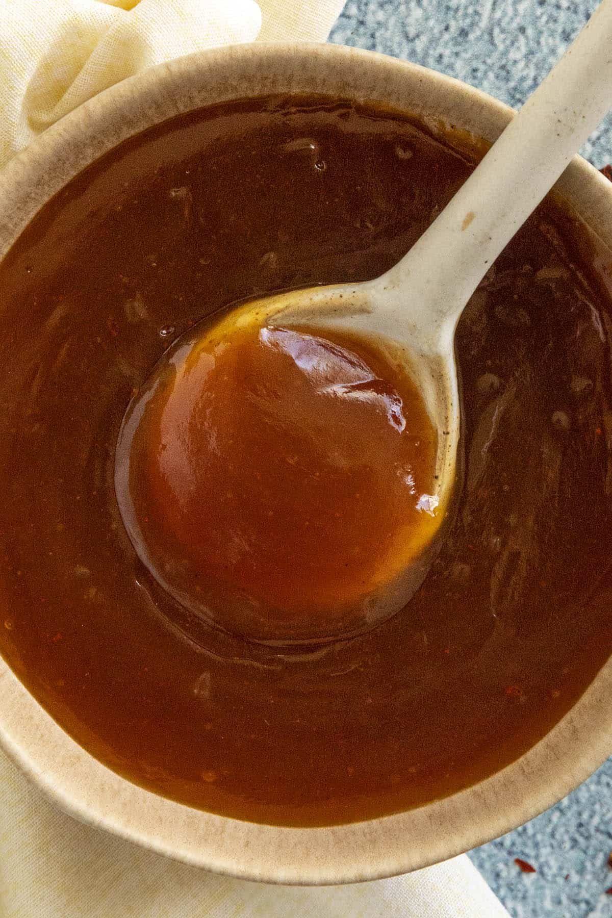 A spoon dipped into Sweet and Sour Sauce