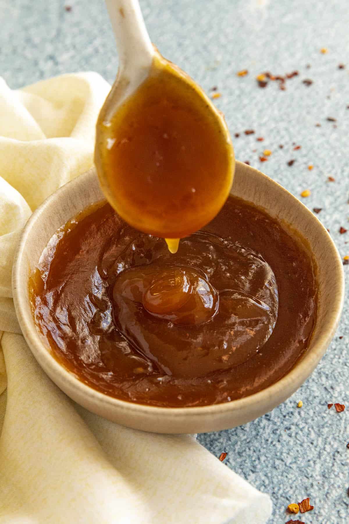 Sweet and Sour Sauce dripping from a spoon into a bowl