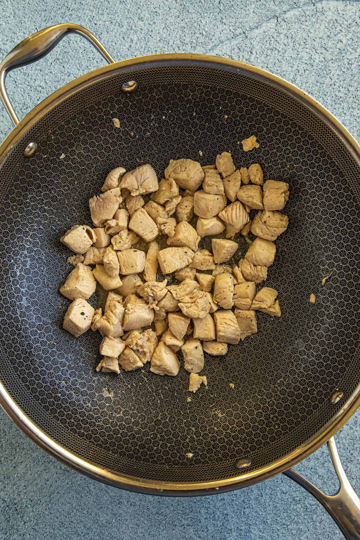 Stir frying the chicken in a hot pan to make Chicken Lo Mein
