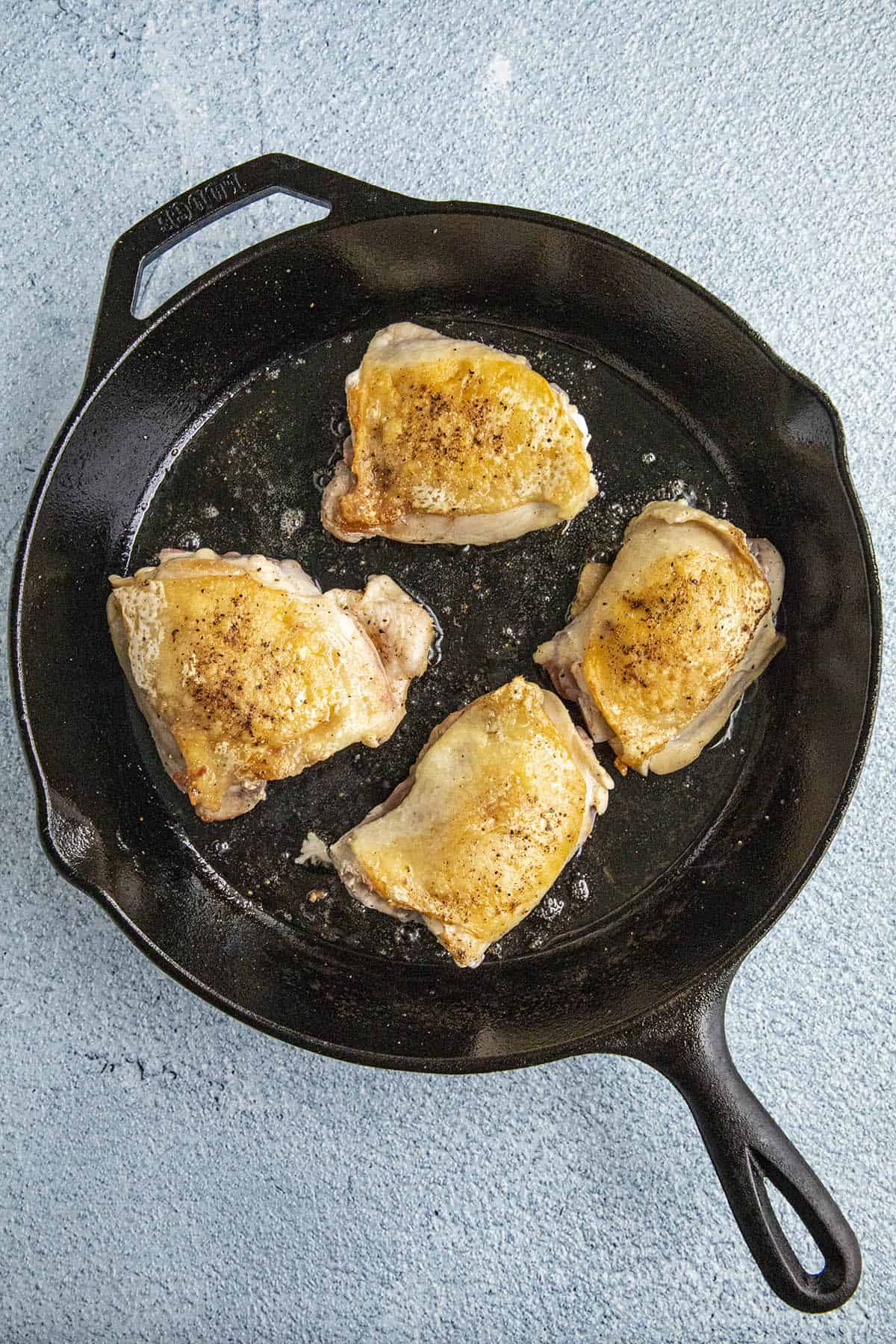 Browning the chicken in a hot pan to make Chicken Scarpariello