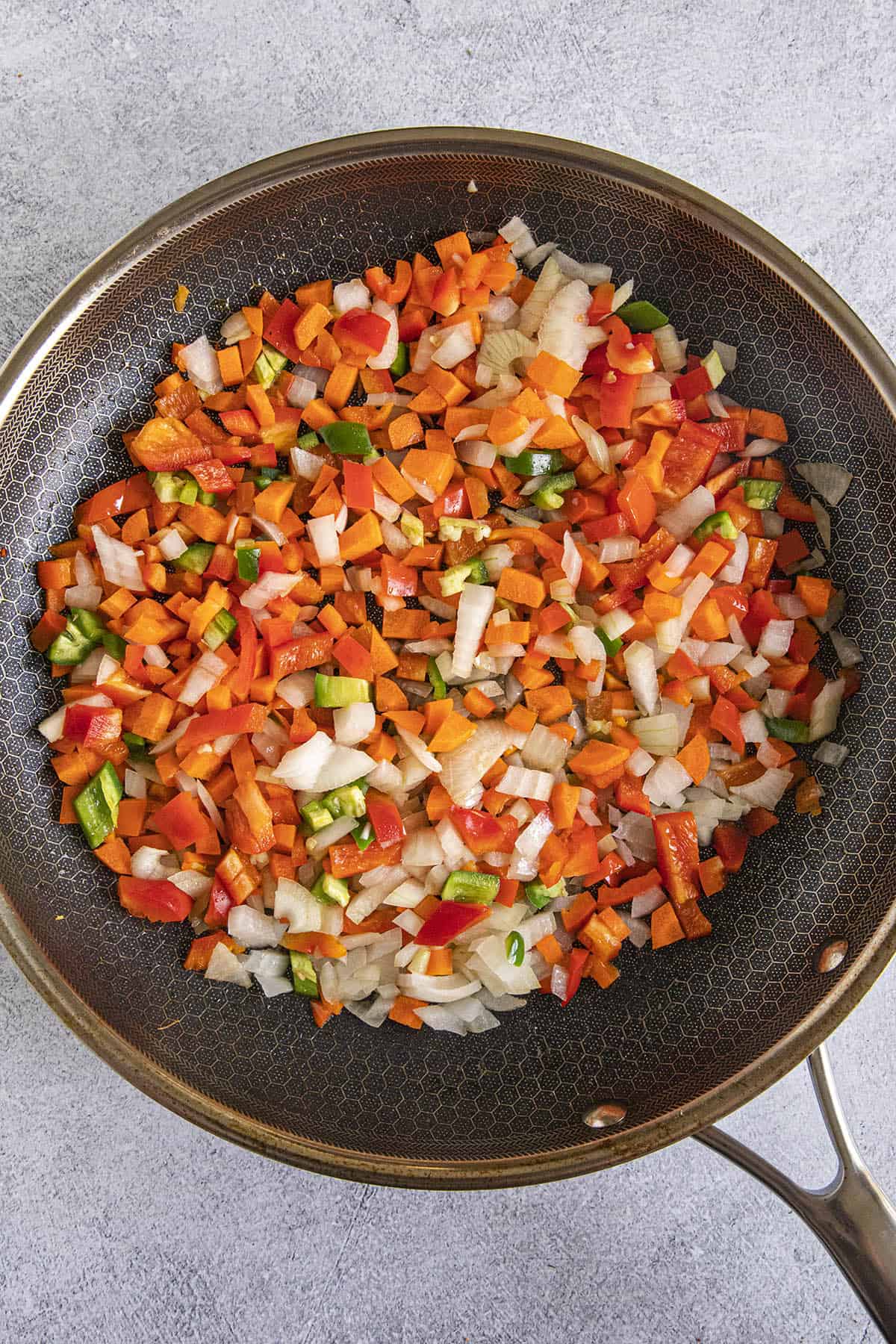 Cooking vegetables in a pan to make Curried Rice