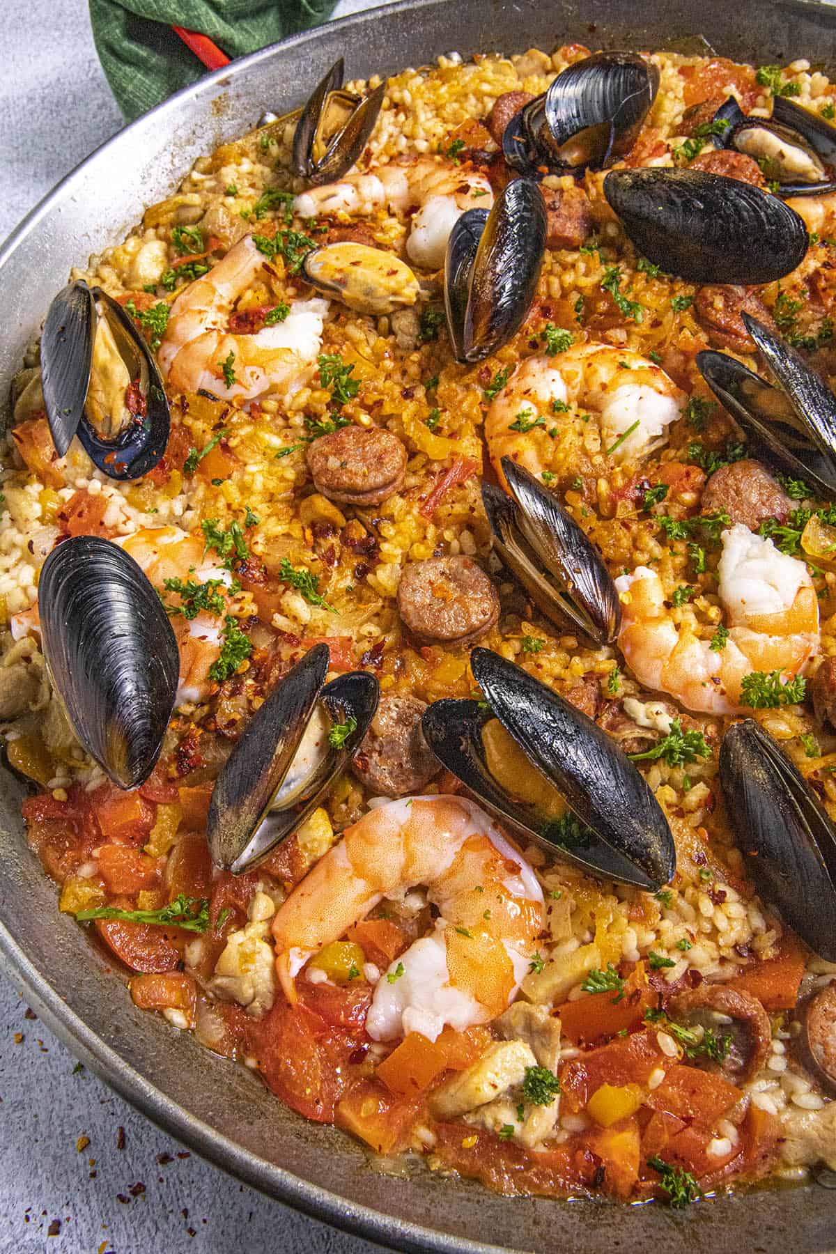Paella in a pan with mussels, shrimp, sausage, and chicken
