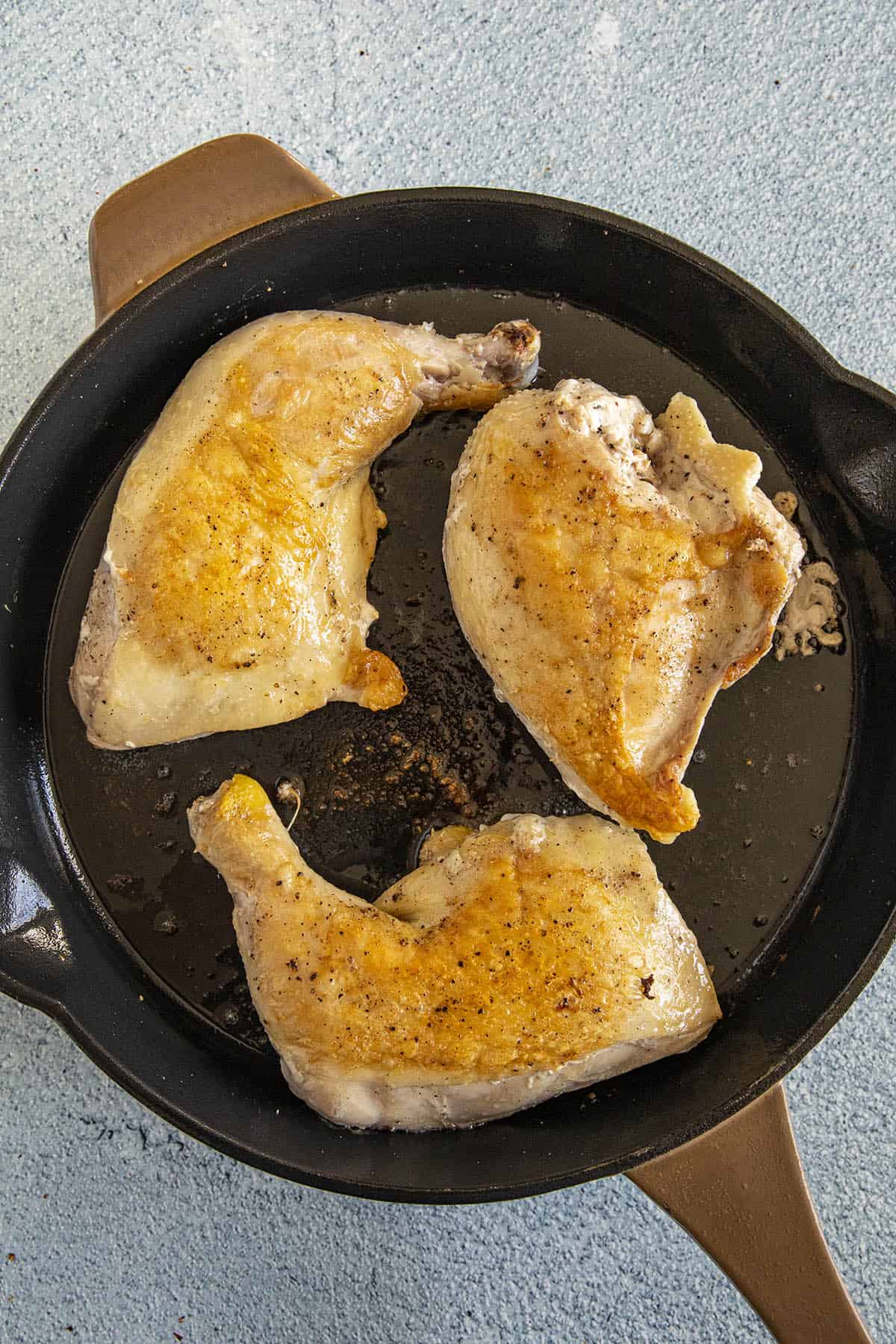 Browning the chicken pieces in a hot pan to make Chicken Cacciatore