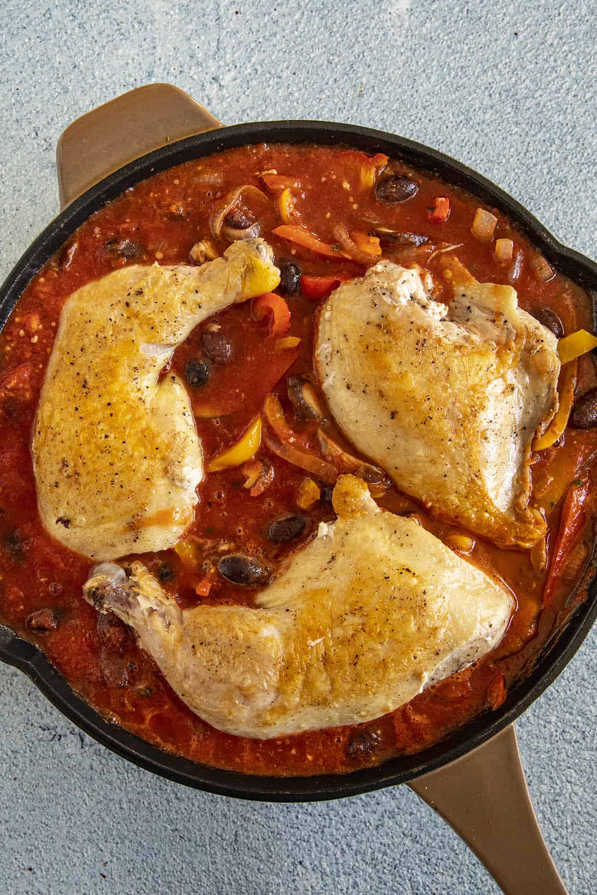 Tucking the browned chicken into the Chicken Cacciatore sauce