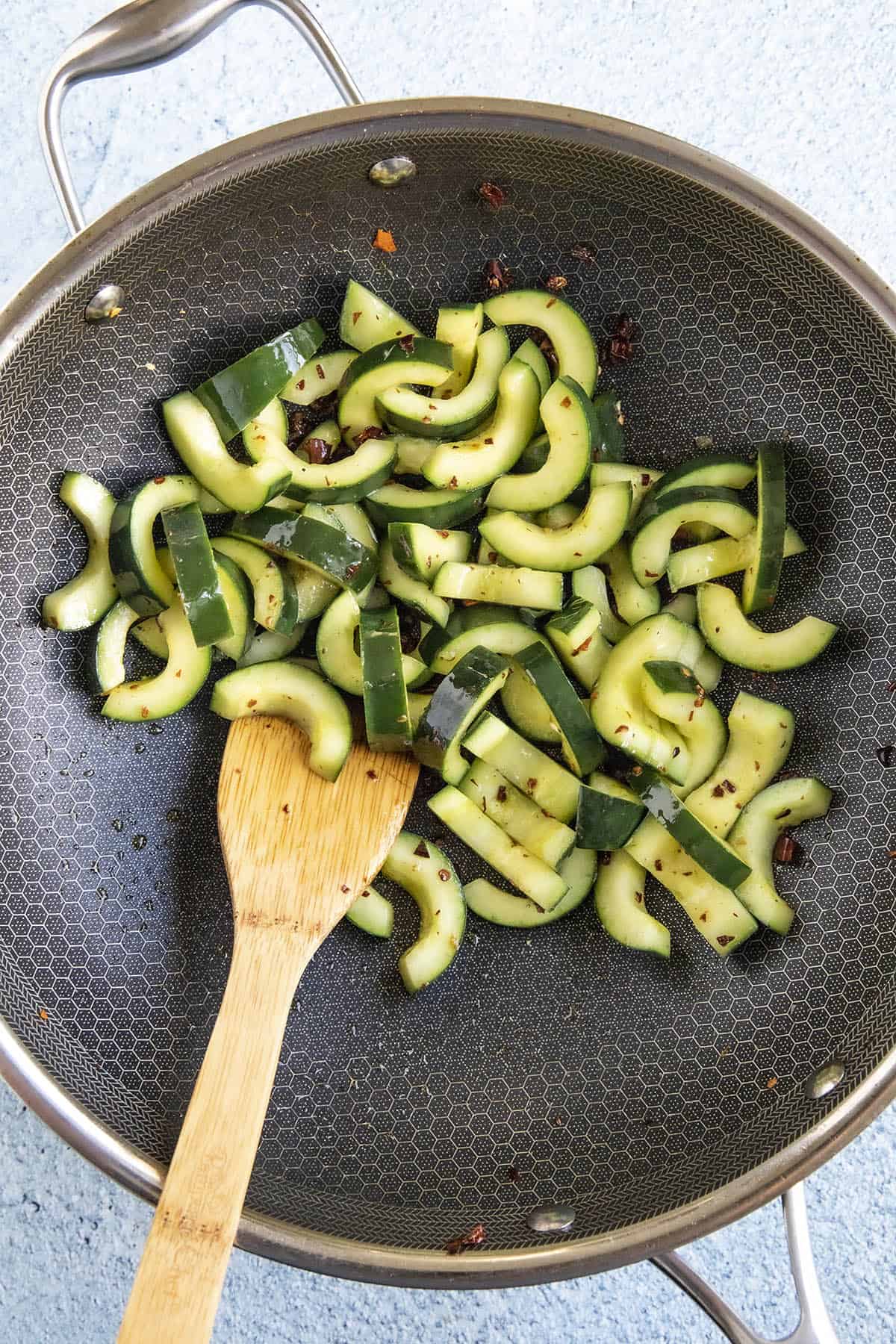 Quickly stir frying the cucumbers with Sichuan spices