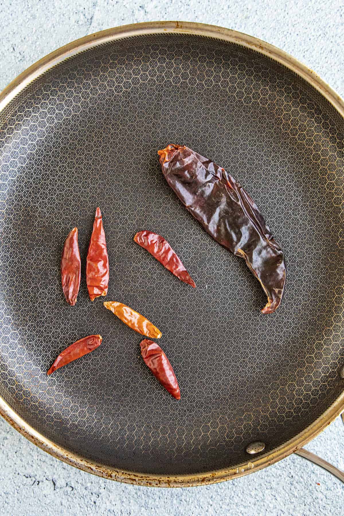 Toasting peppers in a hot pan to make Massaman Curry Paste