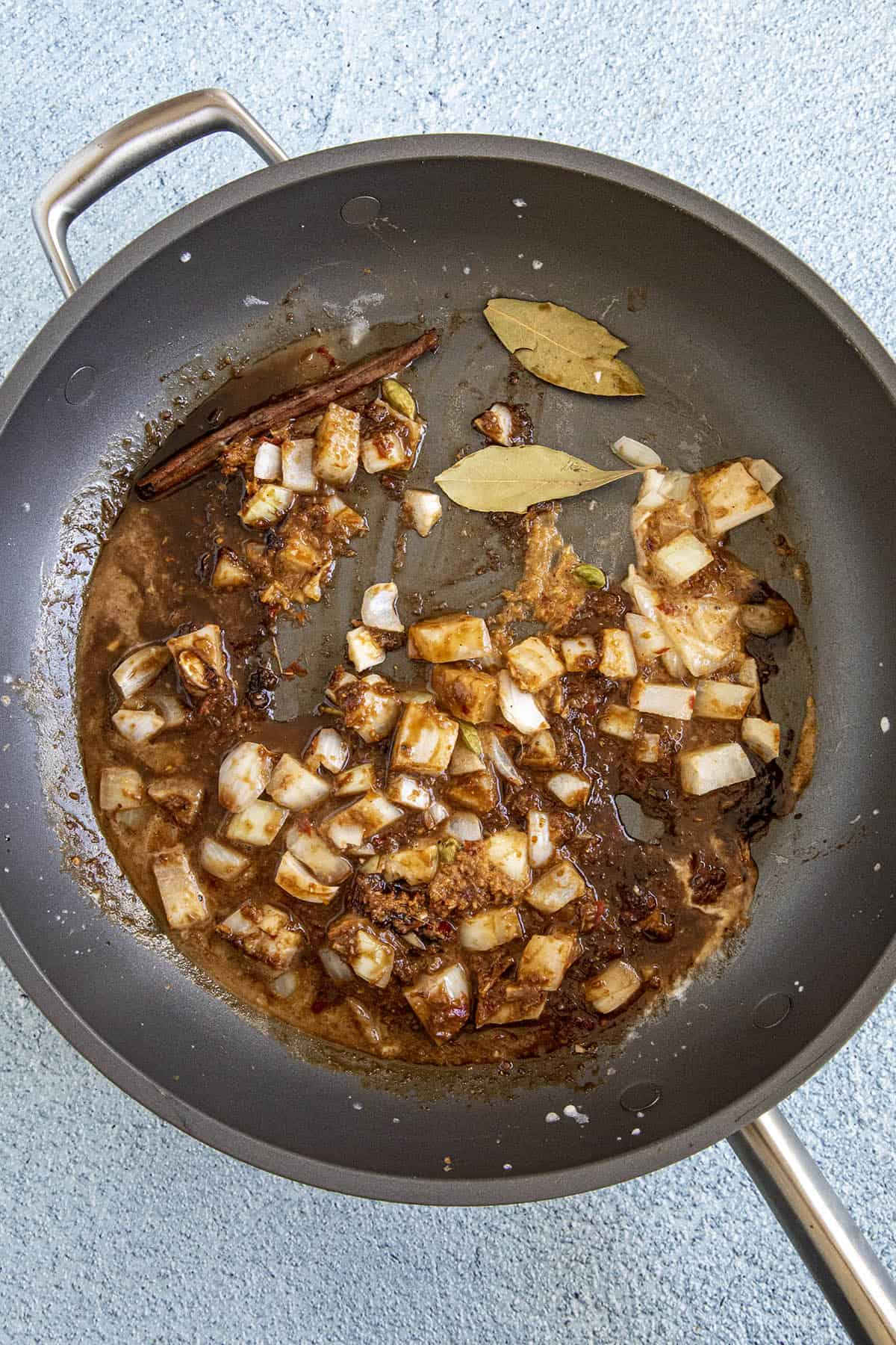 Cooking onion and curry paste in the pan to make Massaman Curry