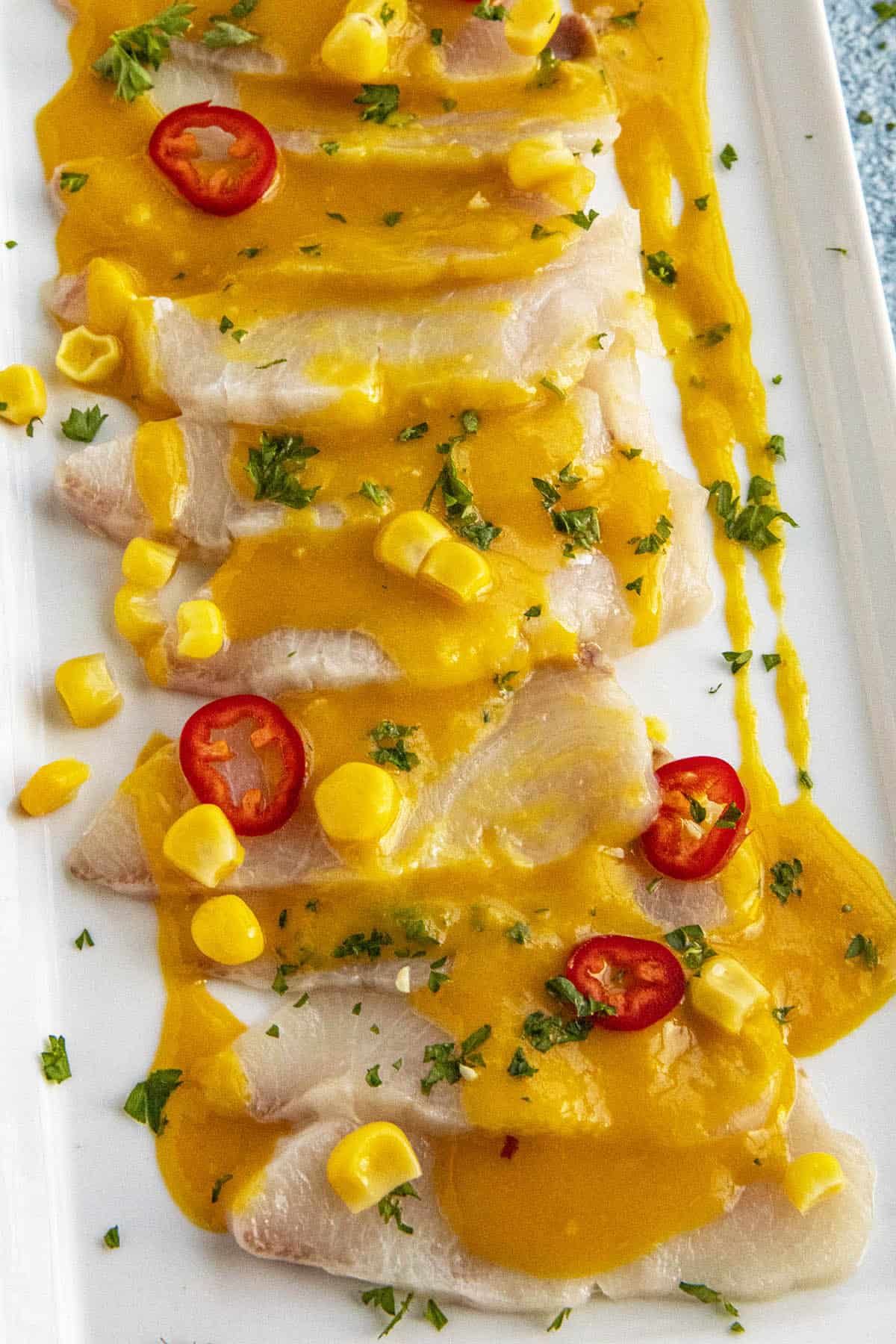 Peruvian Tiradito on a serving platter with aji amarillo sauce