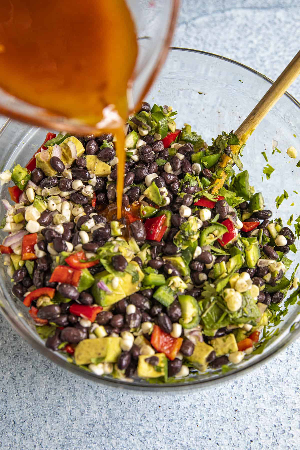 Pouring the vinaigrette into the Black Bean Salad