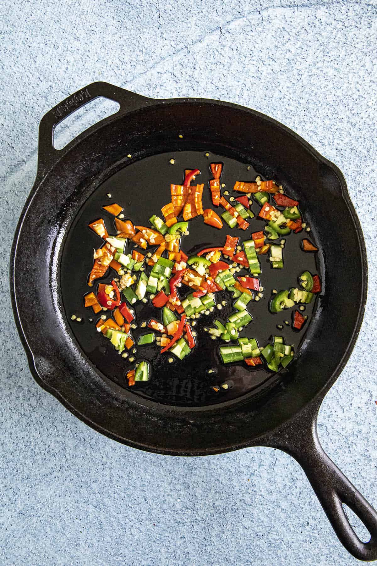 Cooking peppers in a pan to make Buffalo Chicken Dip