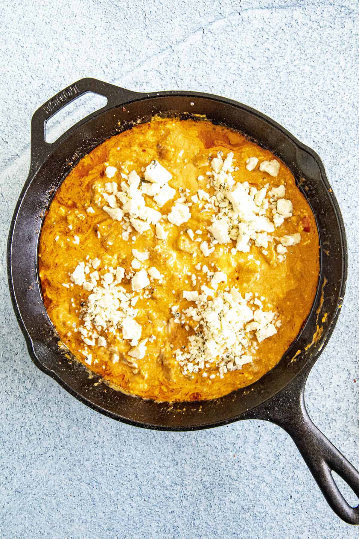 Buffalo Chicken Dip ingredients mixed in a pan, ready to bake