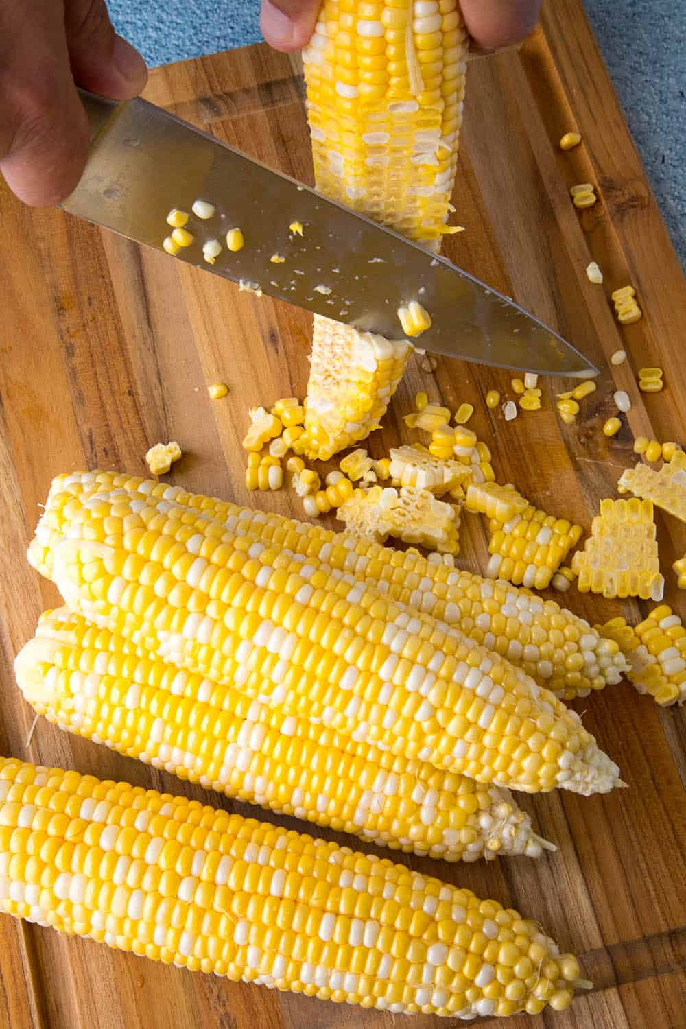 Mike slicing corn from the cob to make Esquites (Mexican Corn Salad)