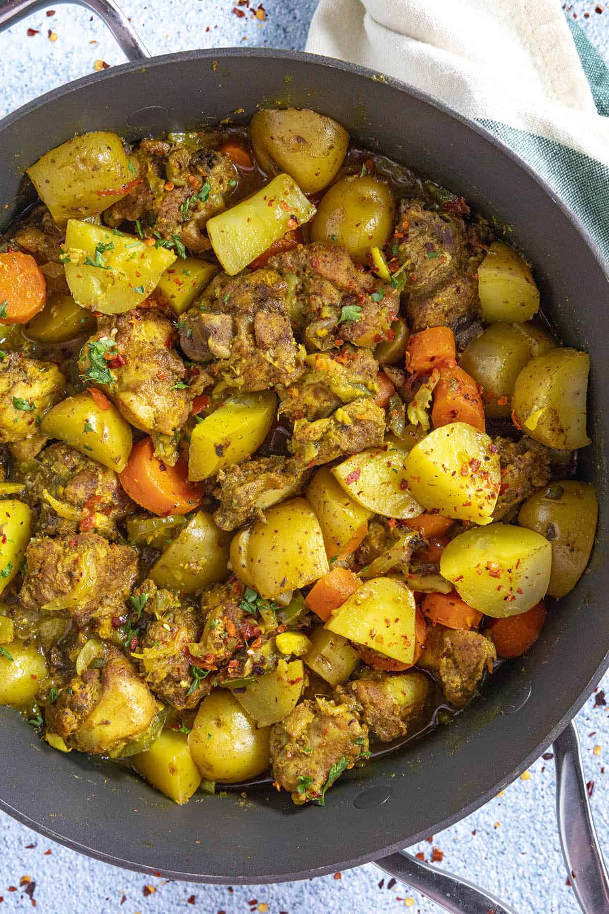 Jamaican Curry Chicken in a pan with potatoes and carrots