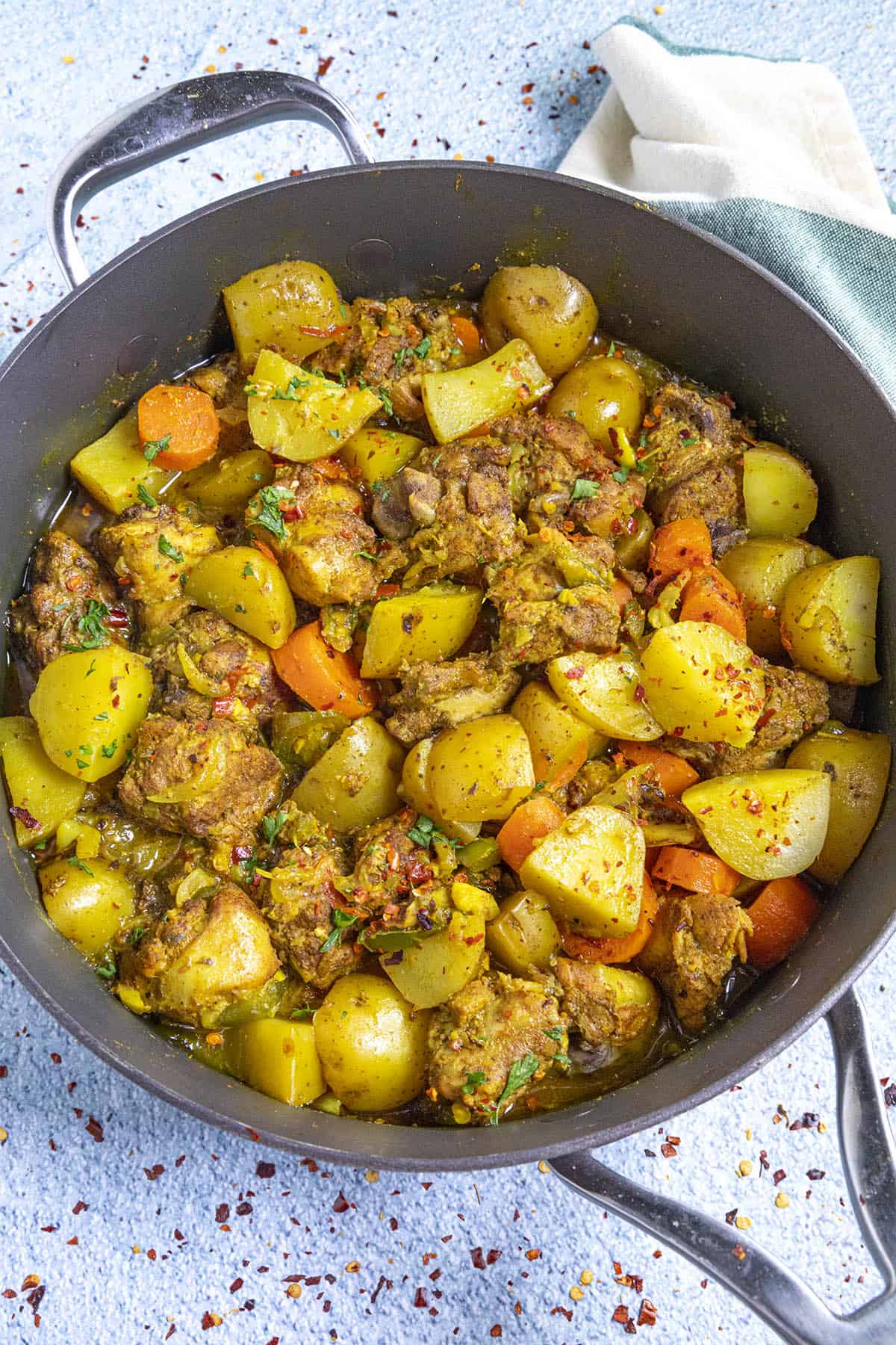 Jamaican Curry Chicken in a pan with garnish