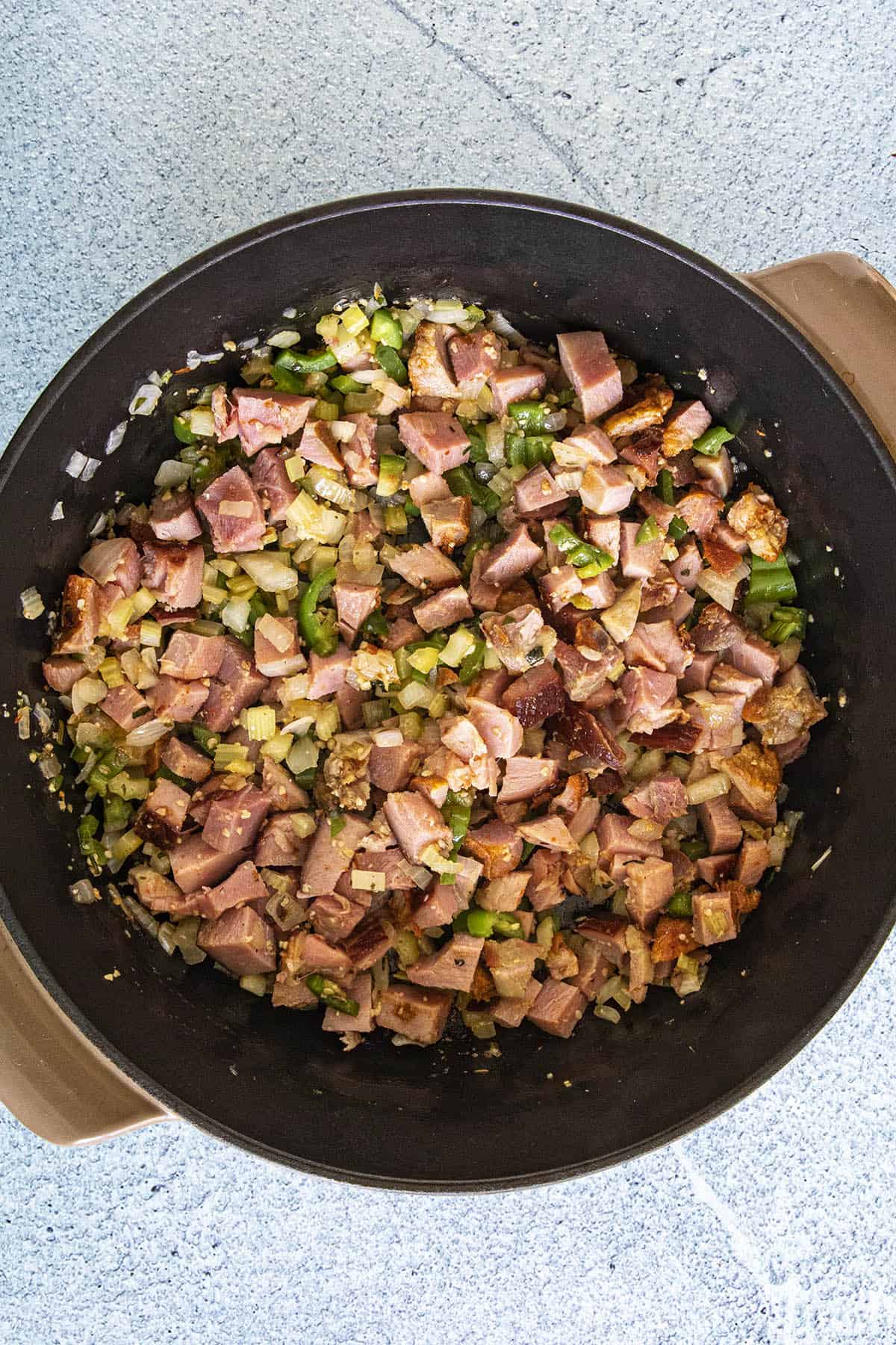 Adding ham to the pot of Red Beans and Rice