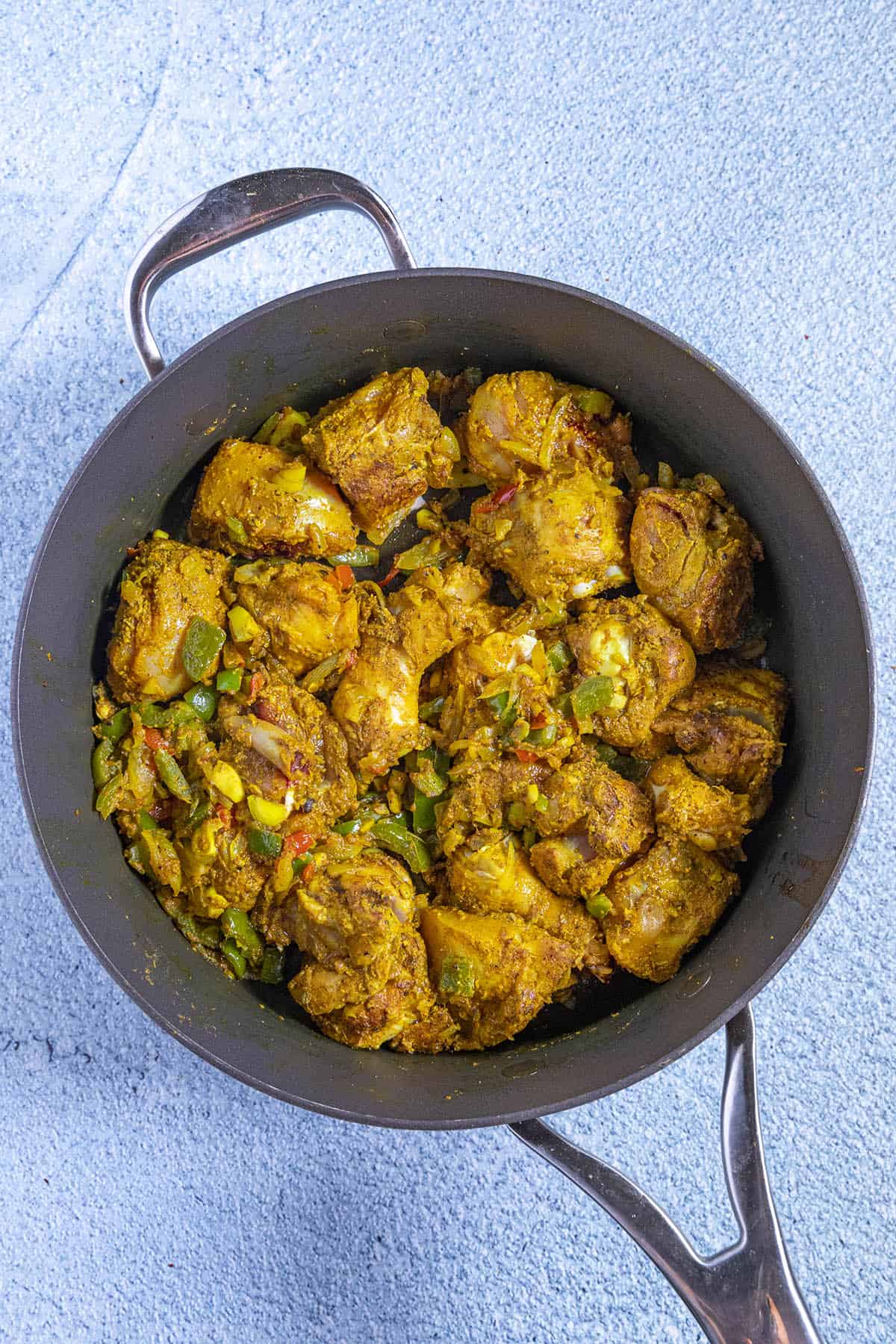 Jamaican Curry Chicken in a pan, ready for the liquids