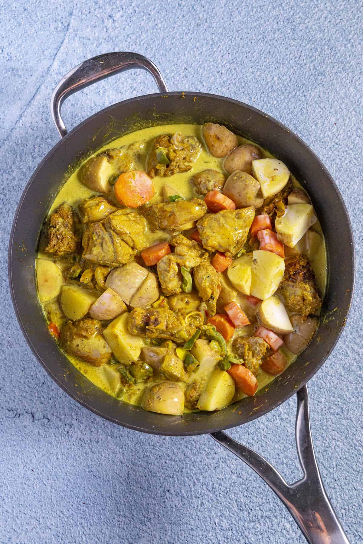 Jamaican Curry Chicken simmering in a pan