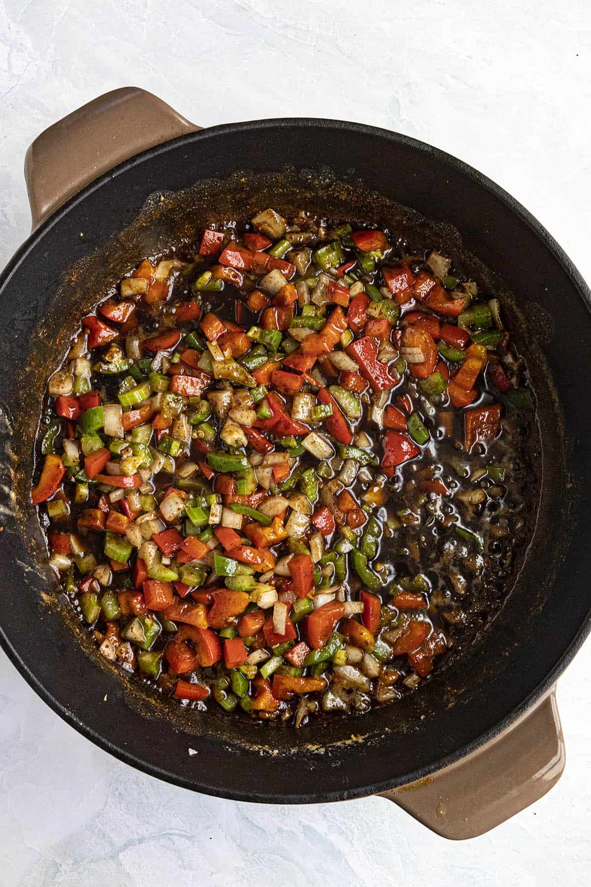 Cooking vegetables in the roux to make Okra Gumbo