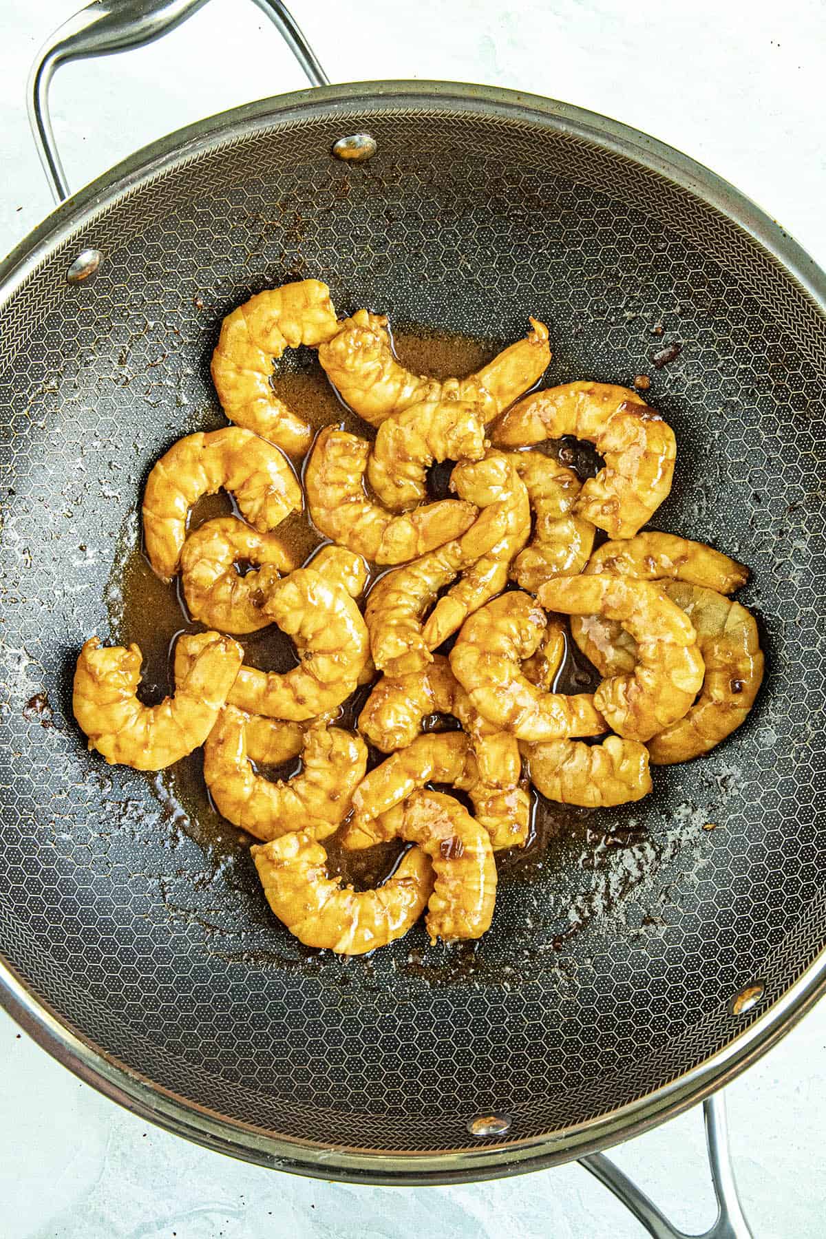 Stir frying marinated shrimp to make Kung Pao Shrimp