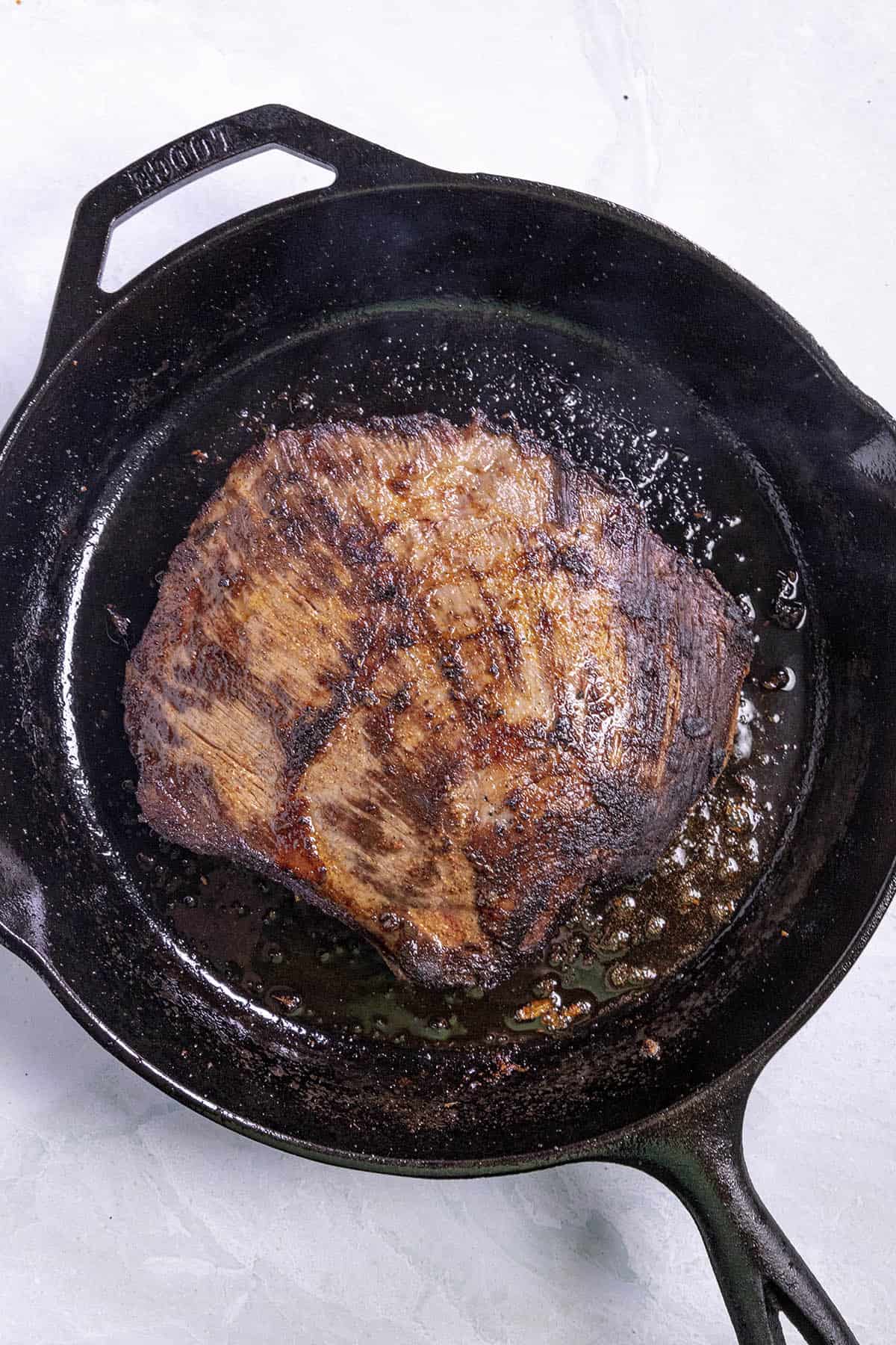Searing the marinated flank steak to make Steak Fajitas