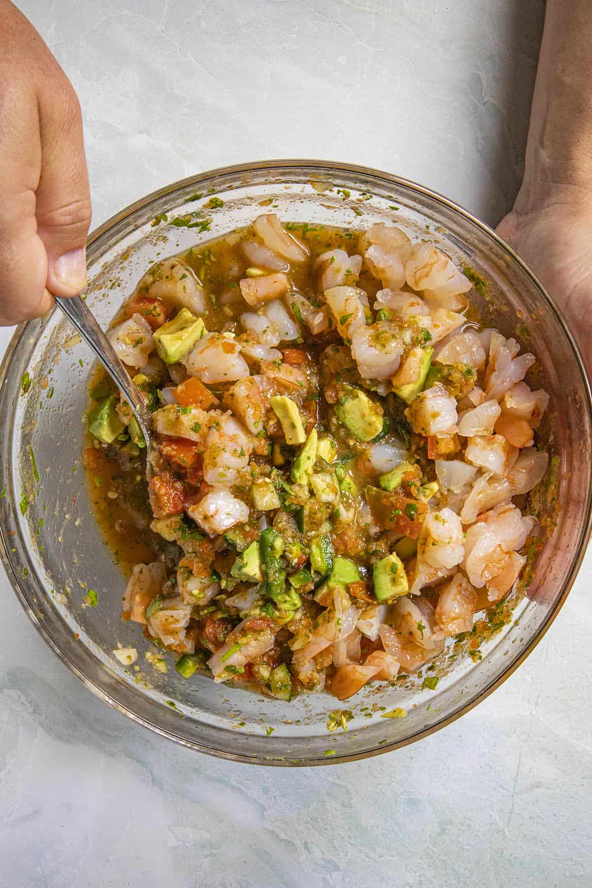 Mixing shrimp into the bowl to make Mexican Shrimp Cocktail