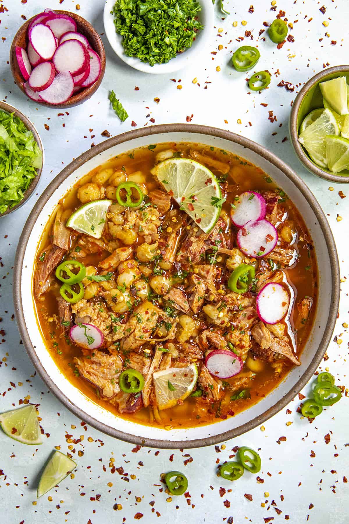 A bowl full of Pozole Rojo with garnish
