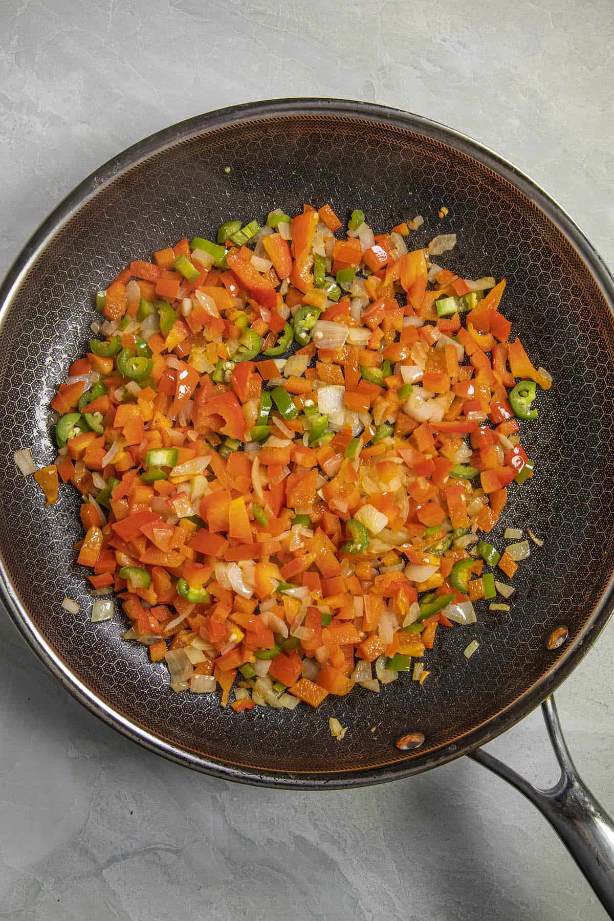 Cooking vegetables in a pan to make Shakshuka