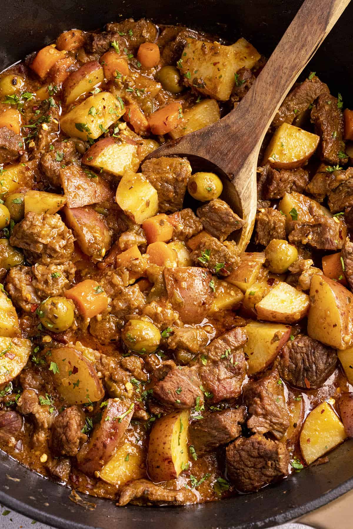 A large spoonful of Carne Guisada being served