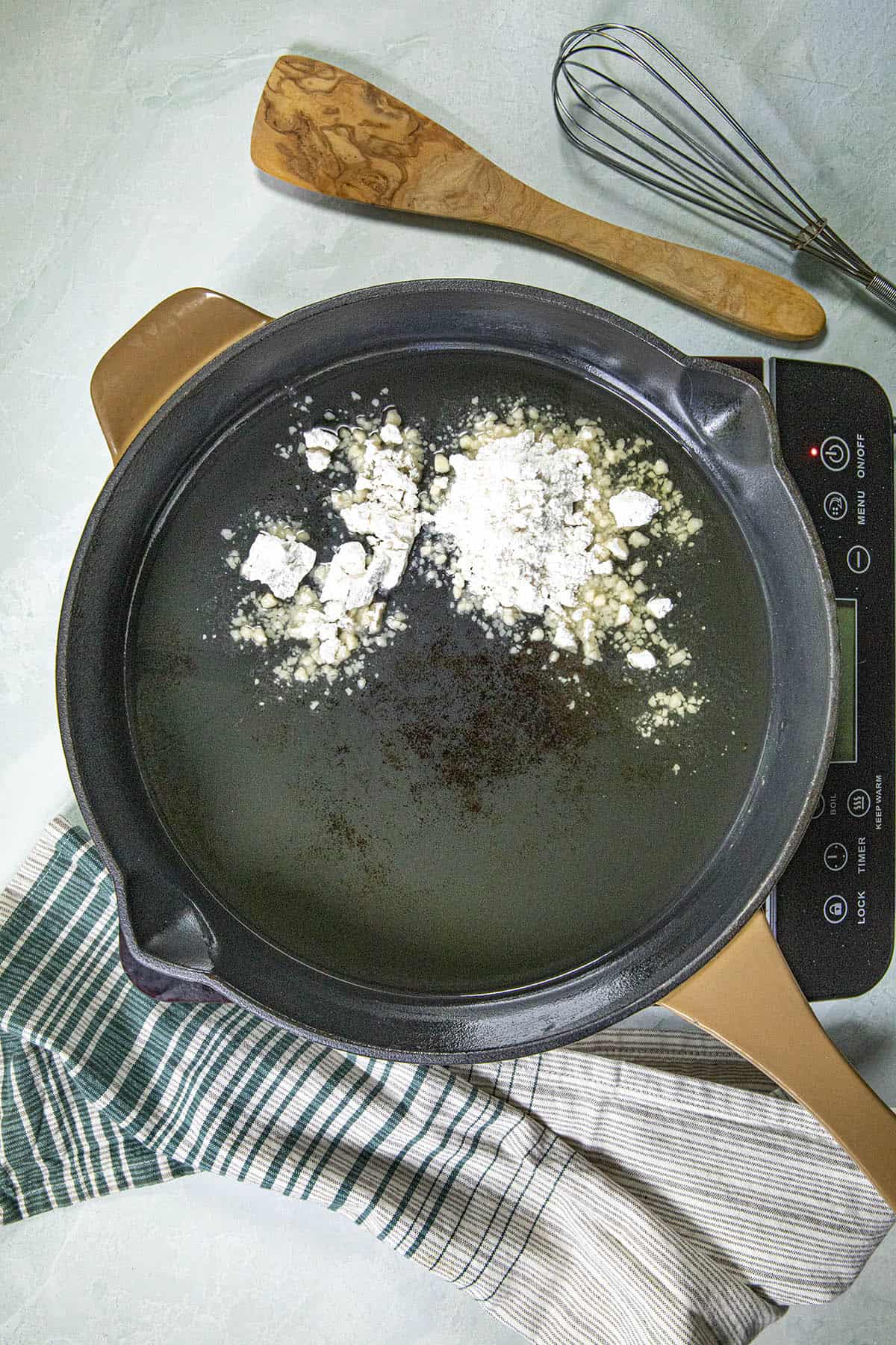 Adding flour and oil to a pan to make roux