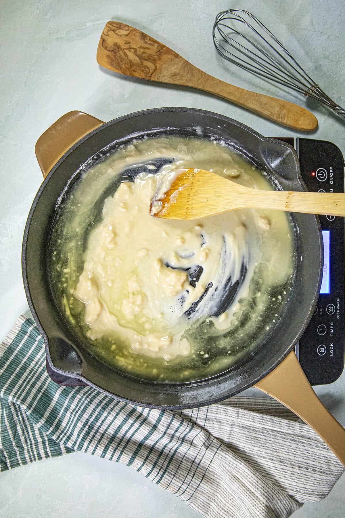 Mixing flour and oil in a pan to make roux