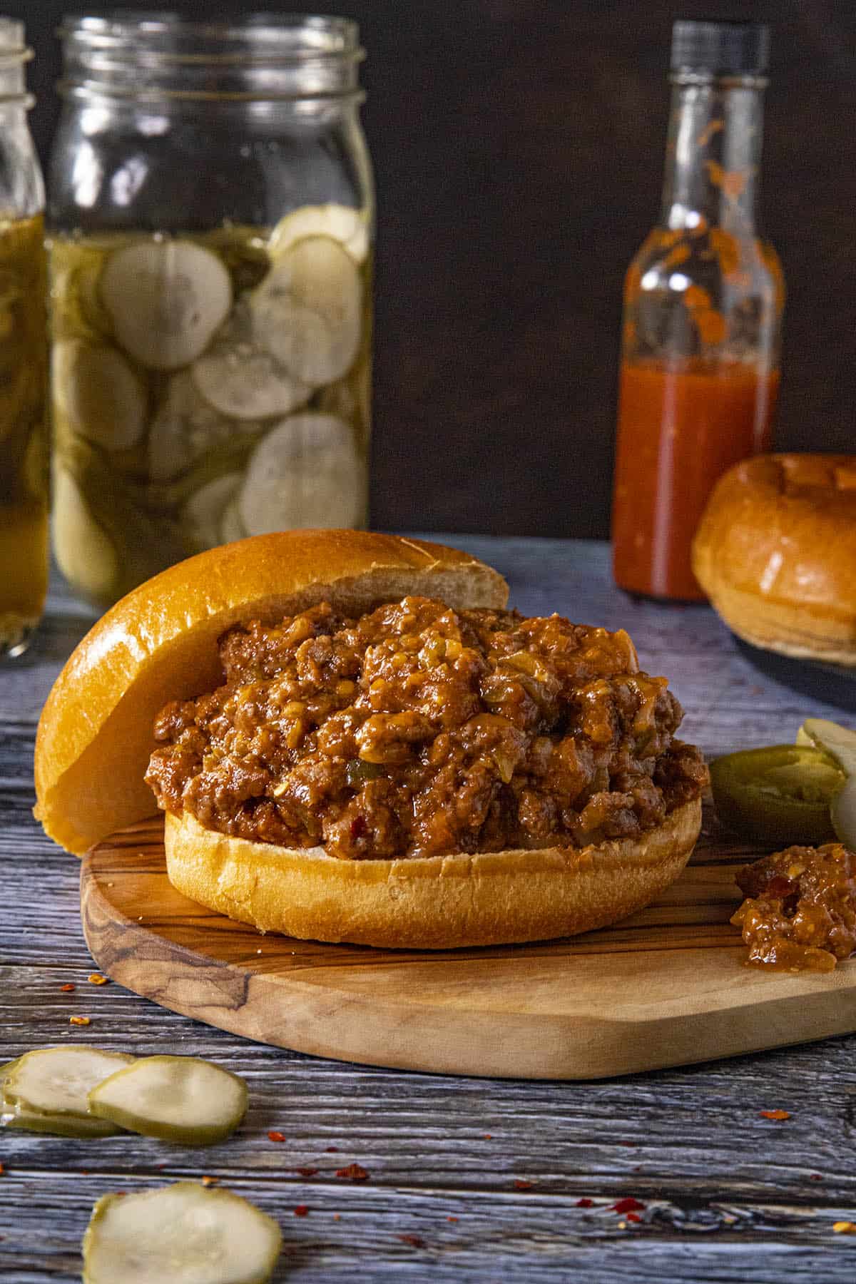 A Sloppy Joes sandwich on a platter with pickles